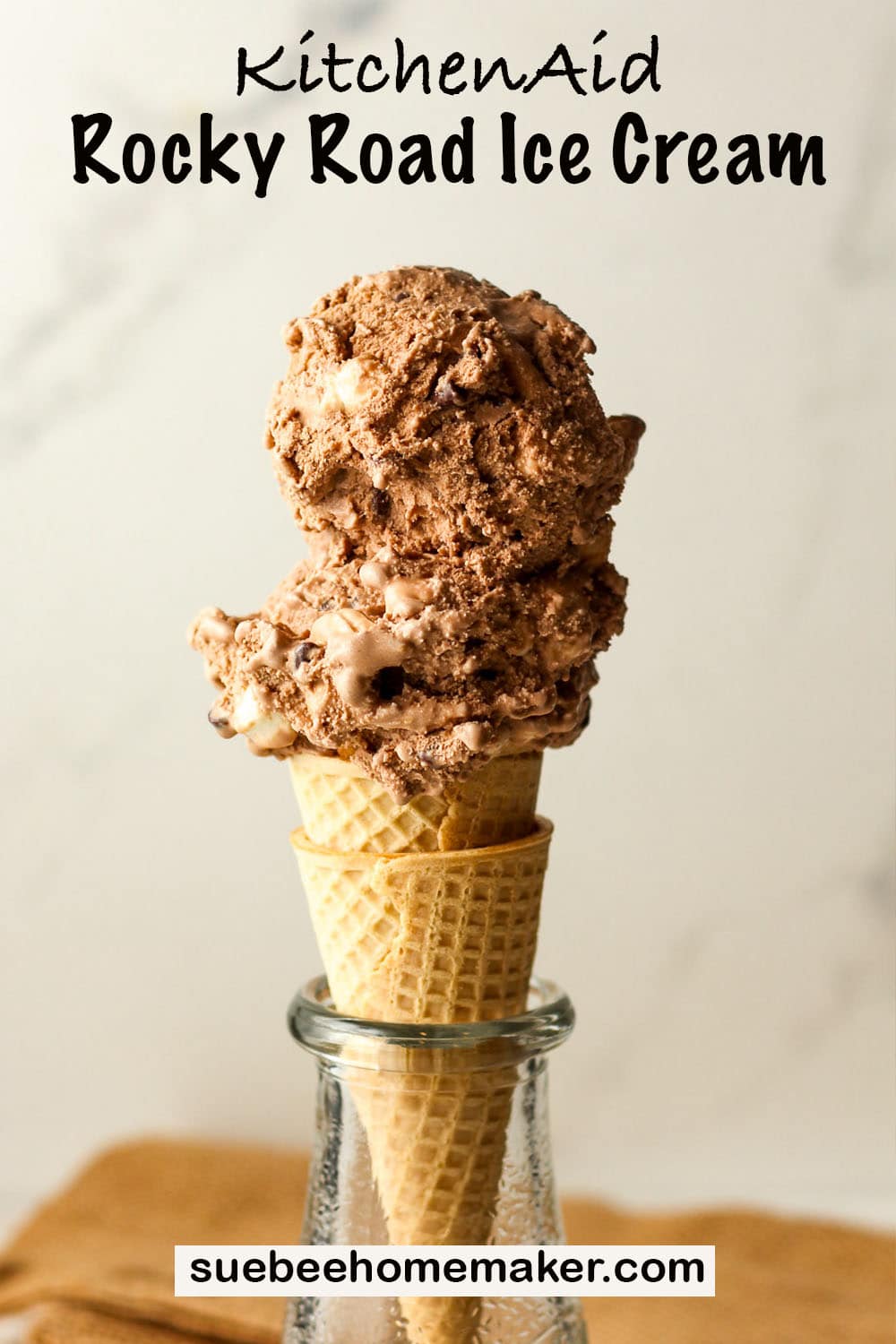 A sugar cone piled high with rocky road ice cream made in the KitchenAid attachment.