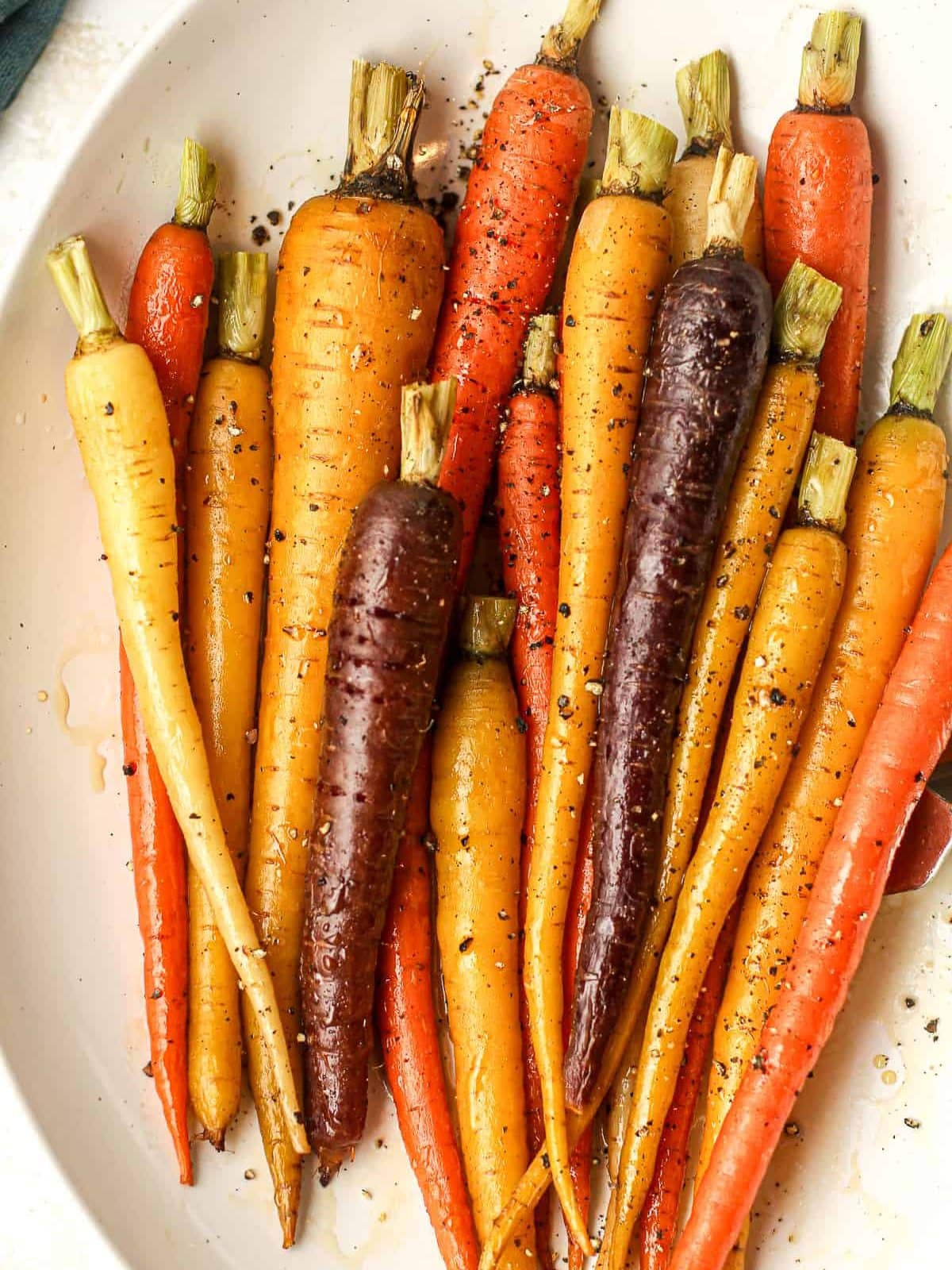 A closeup on some maple roasted carrots in a serving bowl.