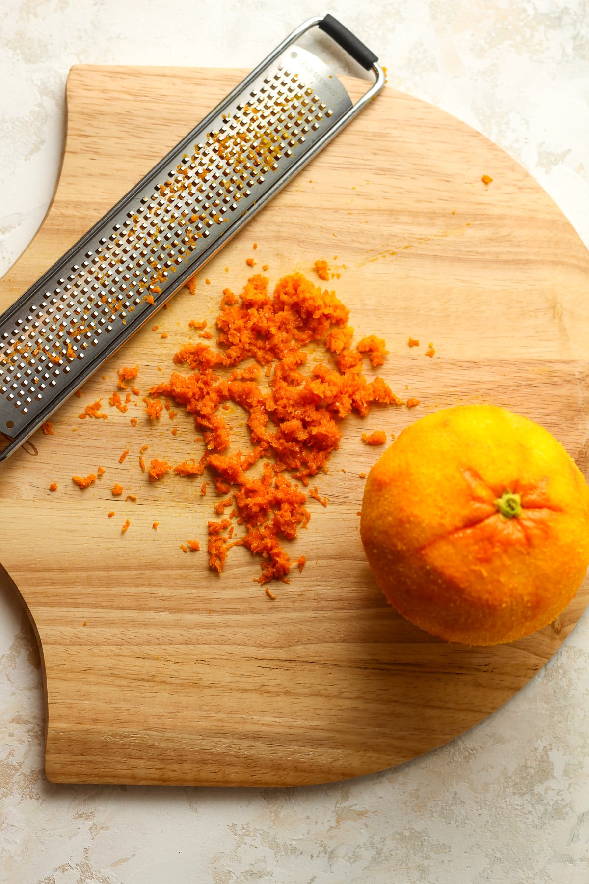 A board with the zested orange.