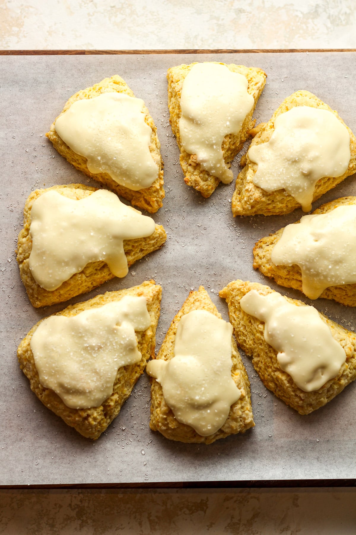 Overhead view of eight glazed orange scones.