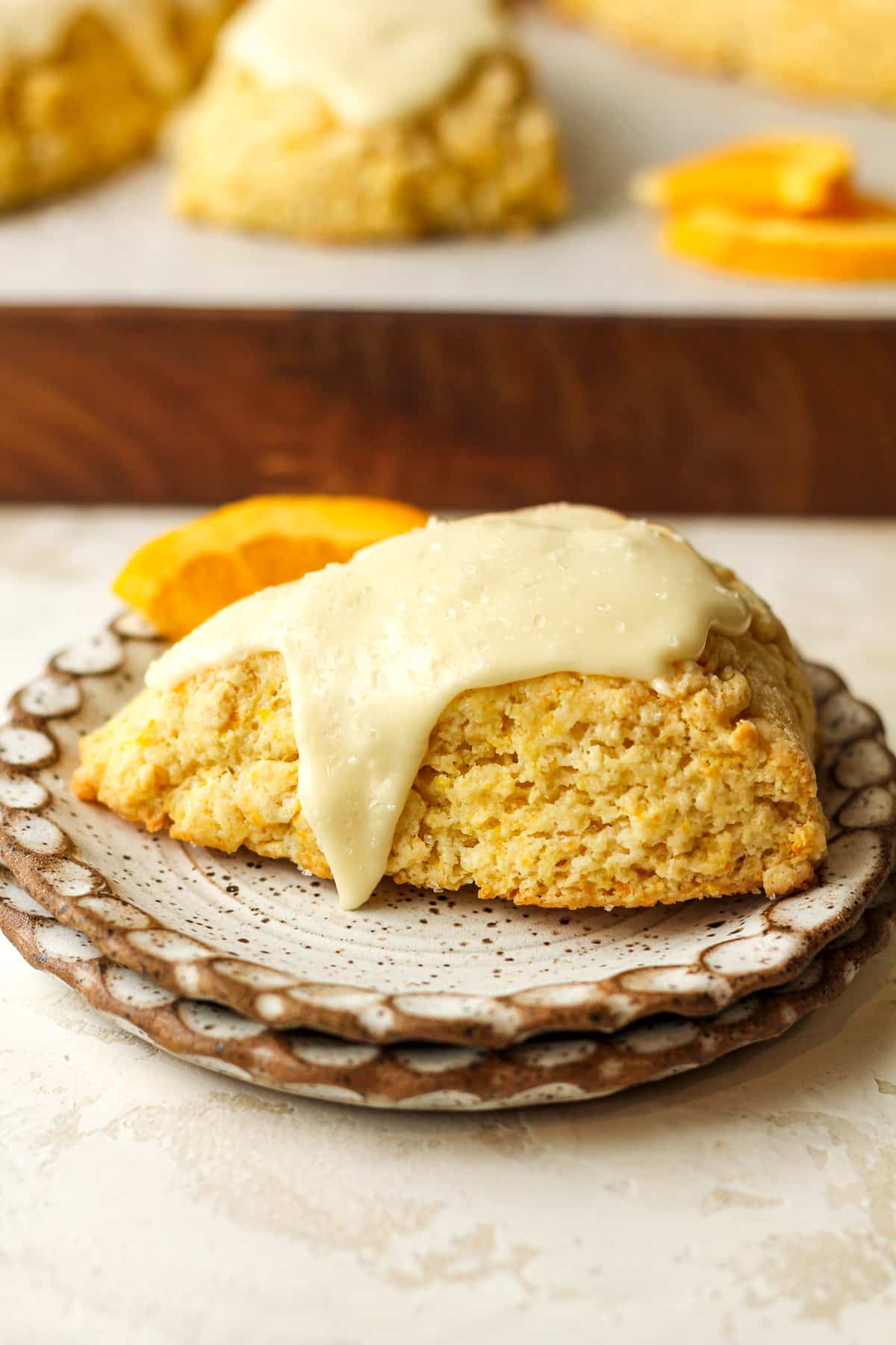 Side view of an orange scone on a plate.