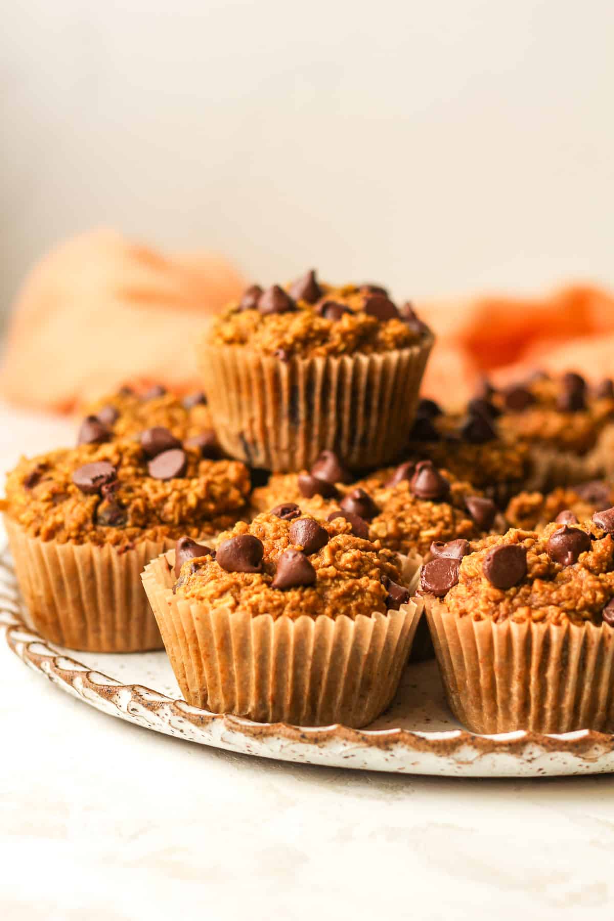 Side view of the plate of muffins with one on top.