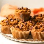 Side view of a plate of pumpkin muffins made with oat flour.