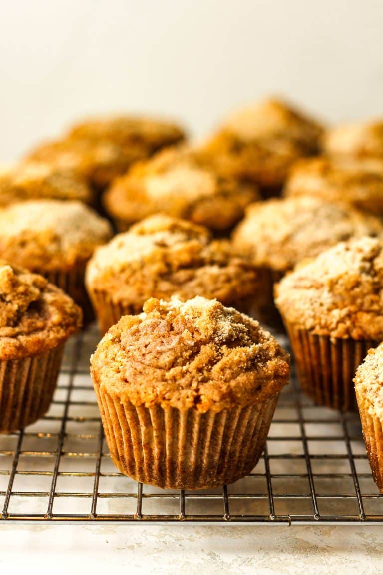 Side view of a wire rack of pumpkin muffins with streusel topping.