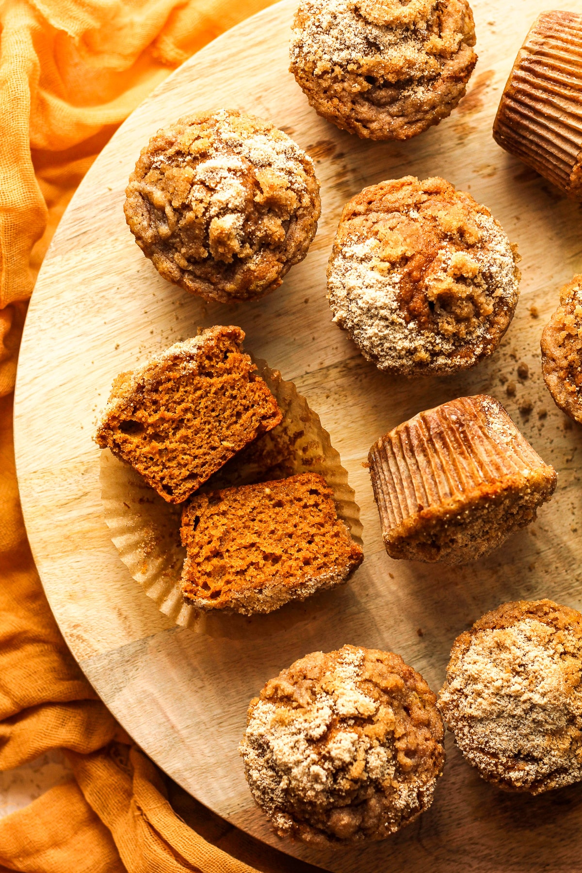 Overhead view of some pumpkin muffins with one cut in half.