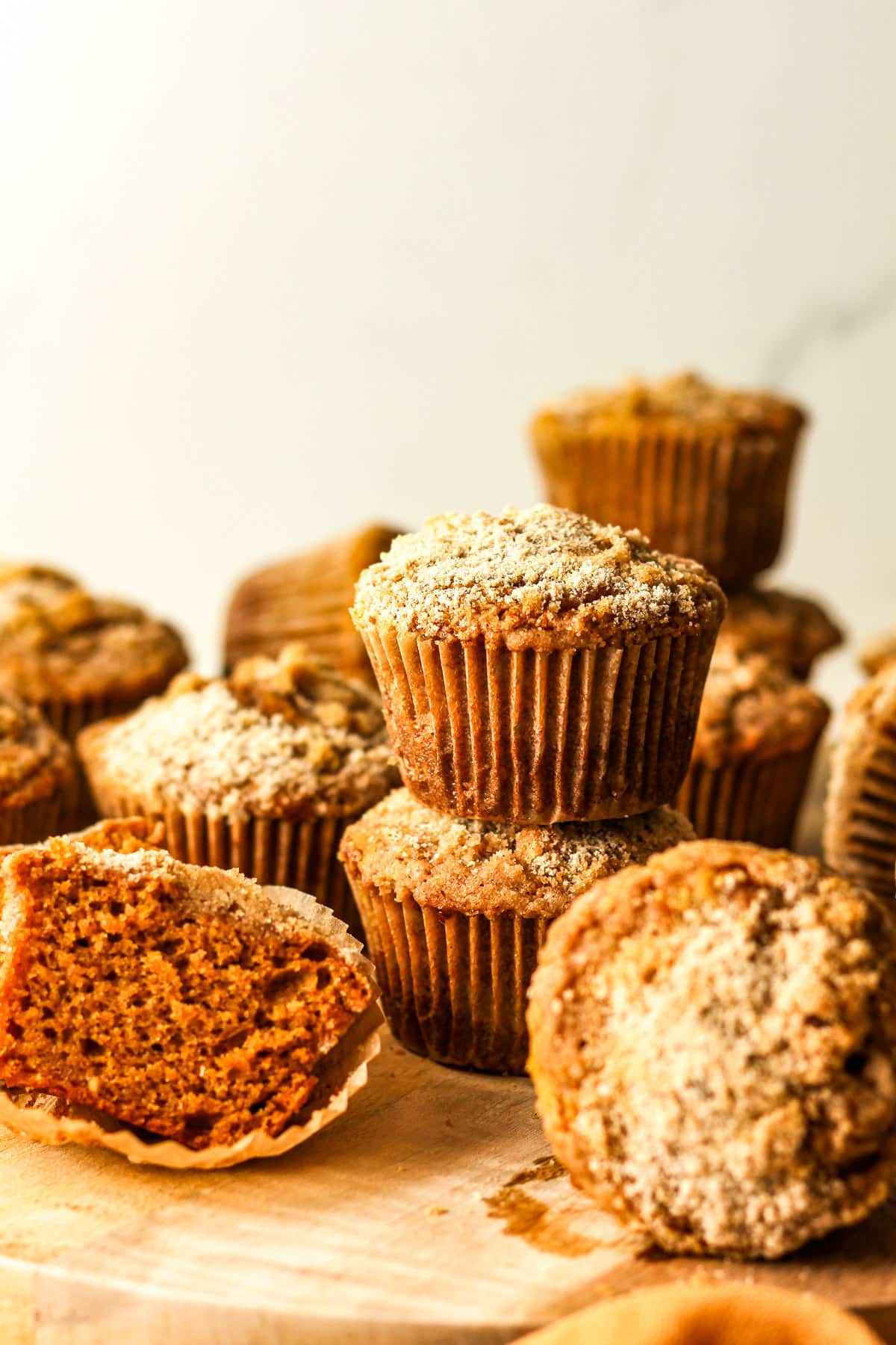 Side view of a tray of stacked pumpkin streusel muffins.