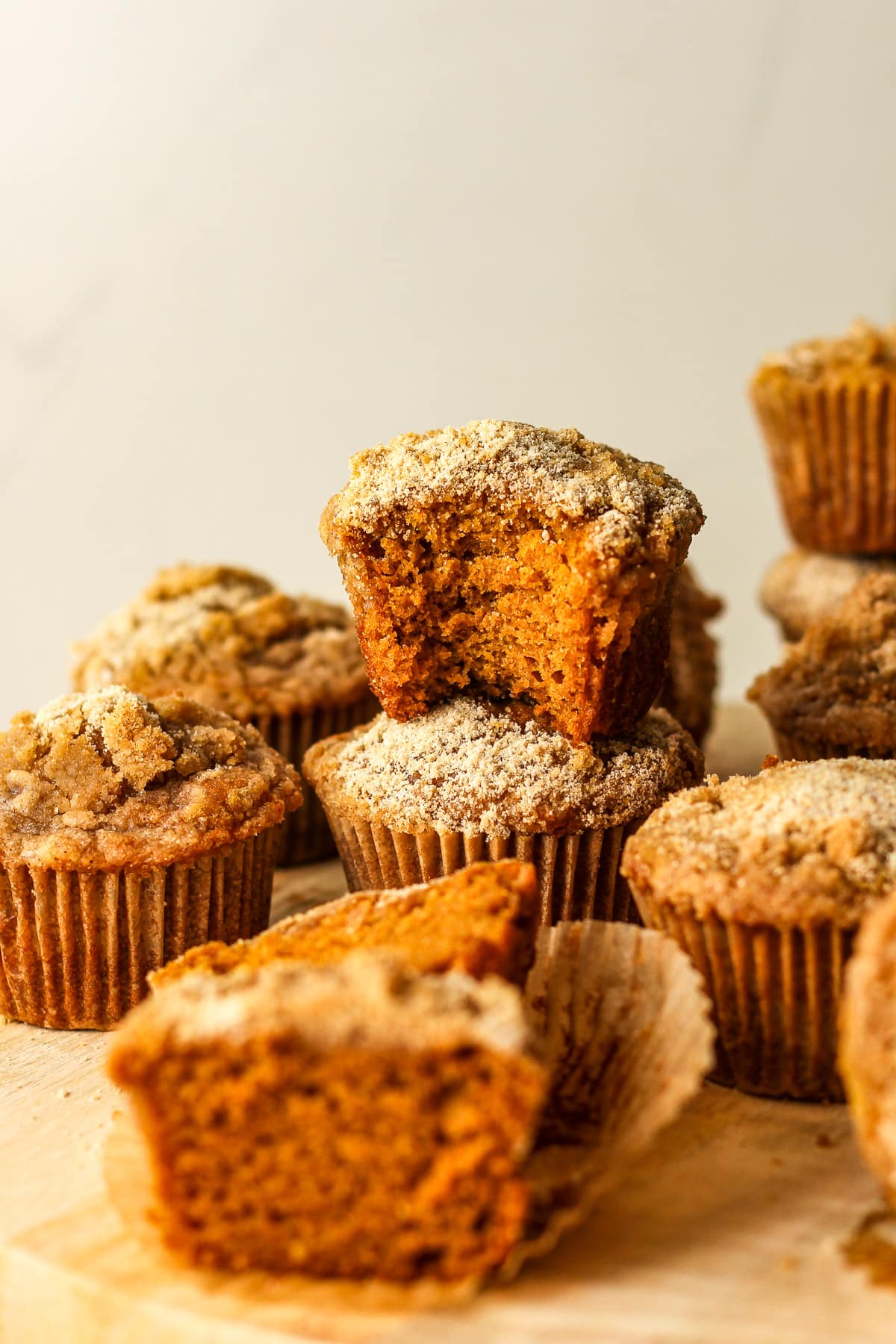 Stacked pumpkin streusel muffins on a tray.