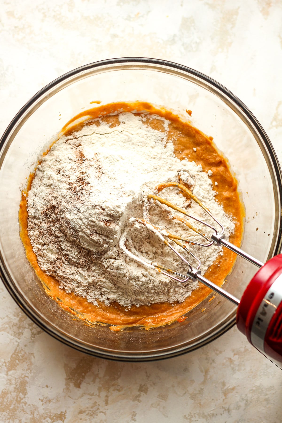 A bowl of the pumpkin wet ingredients plus dry on top.