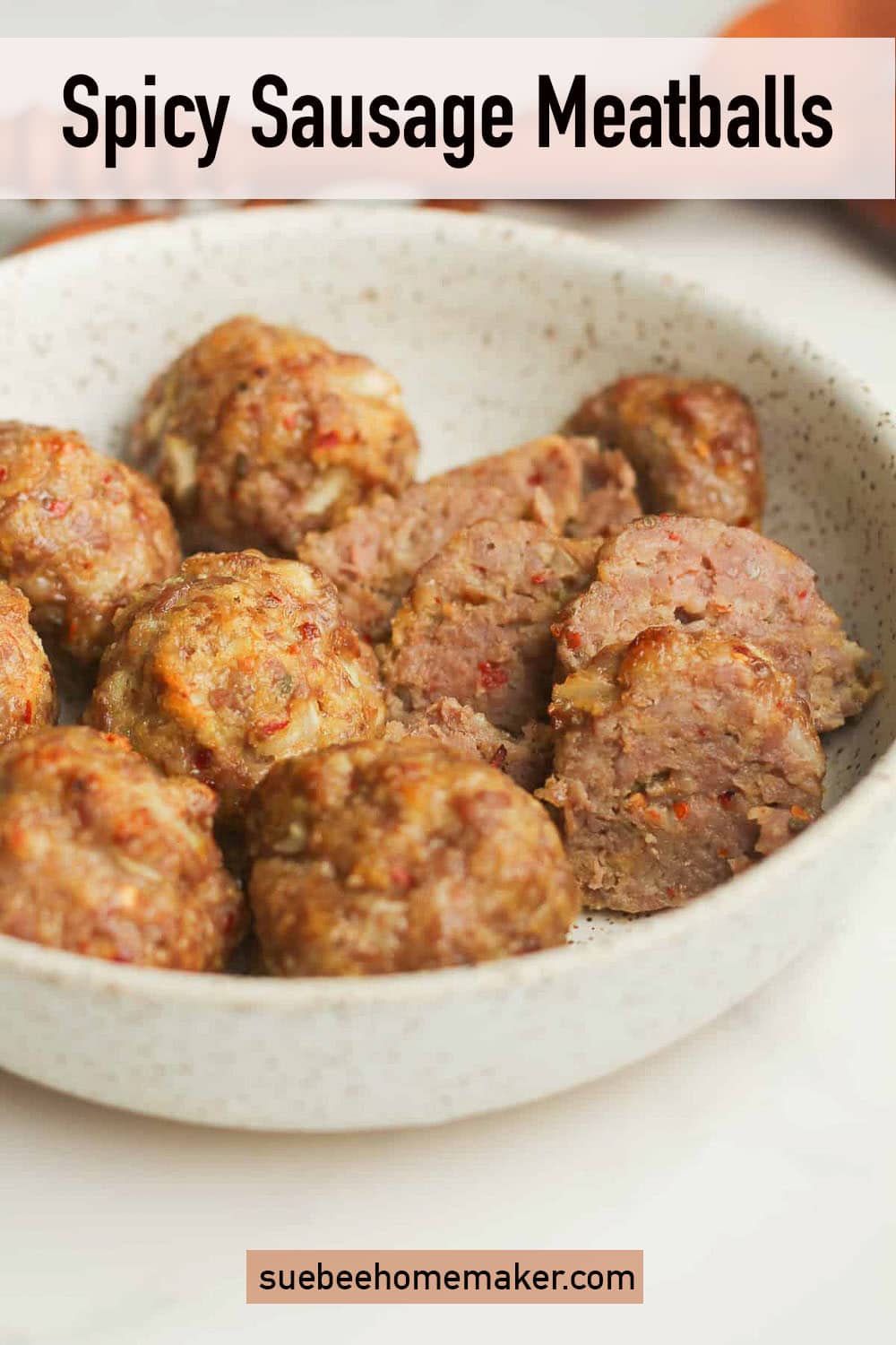 Side view of some baked spicy sausage meatballs.