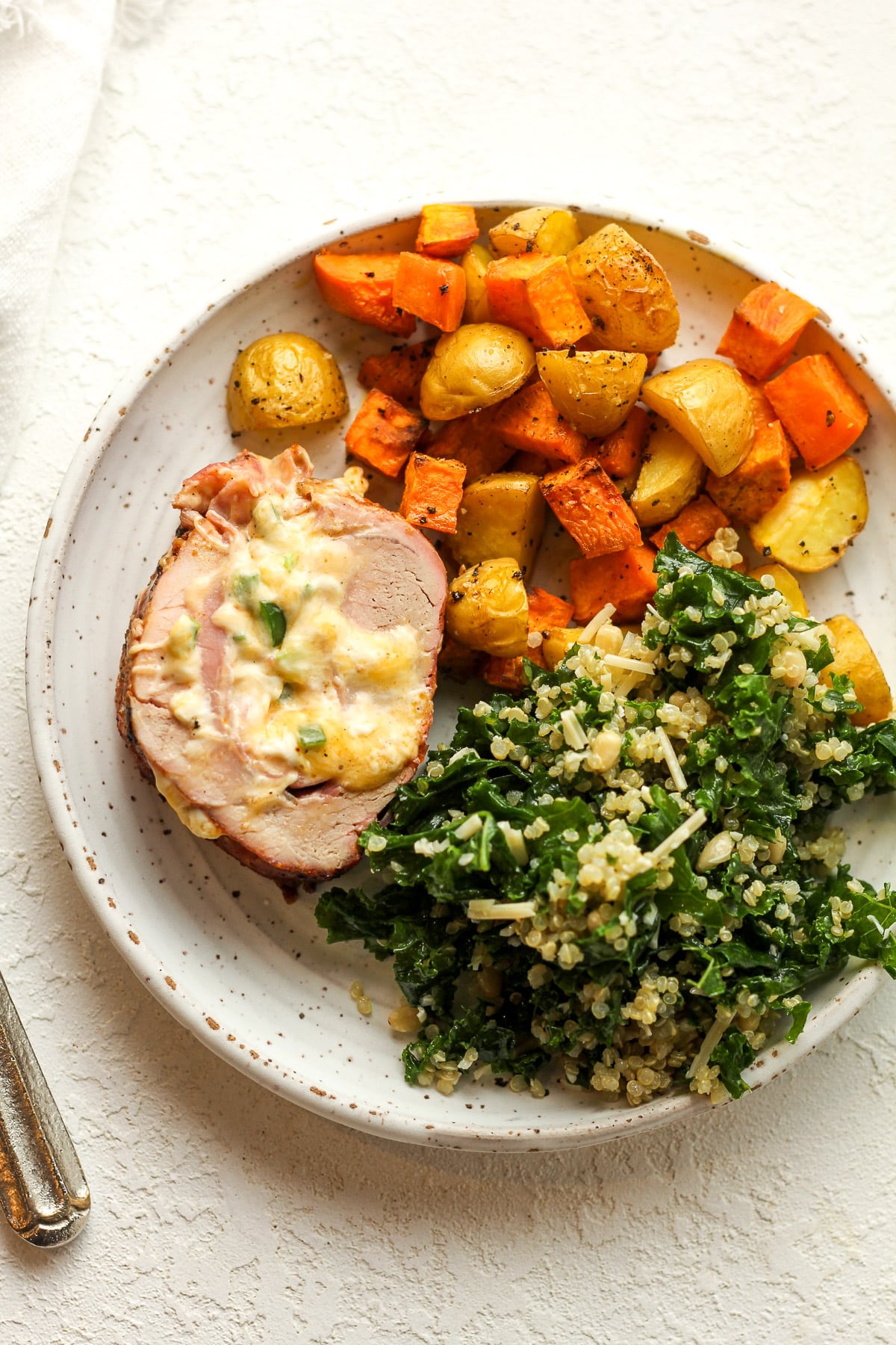 Overhead view of a plate of stuffed pork with veggies.