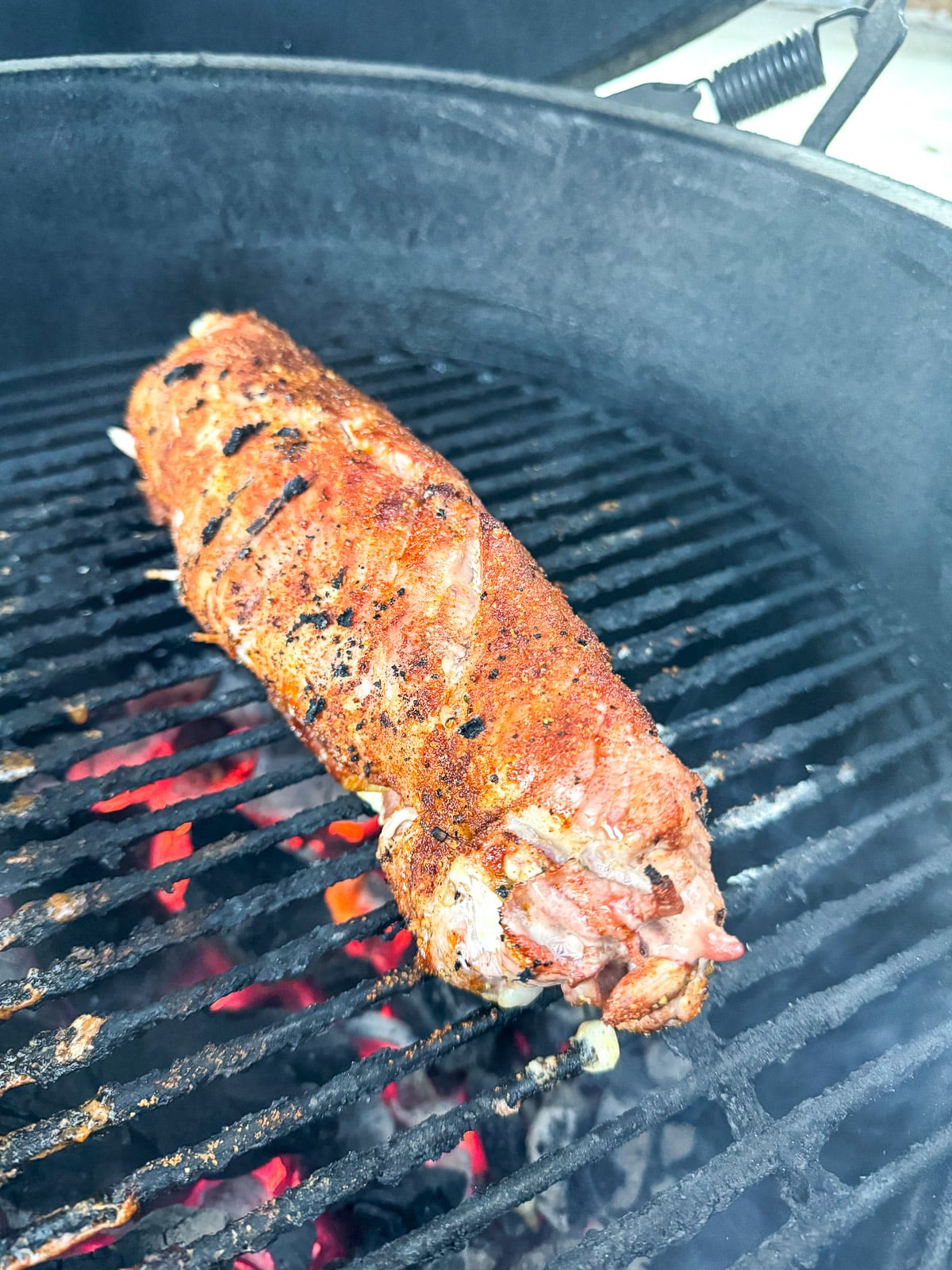 A stuffed pork tenderloin on a grill.