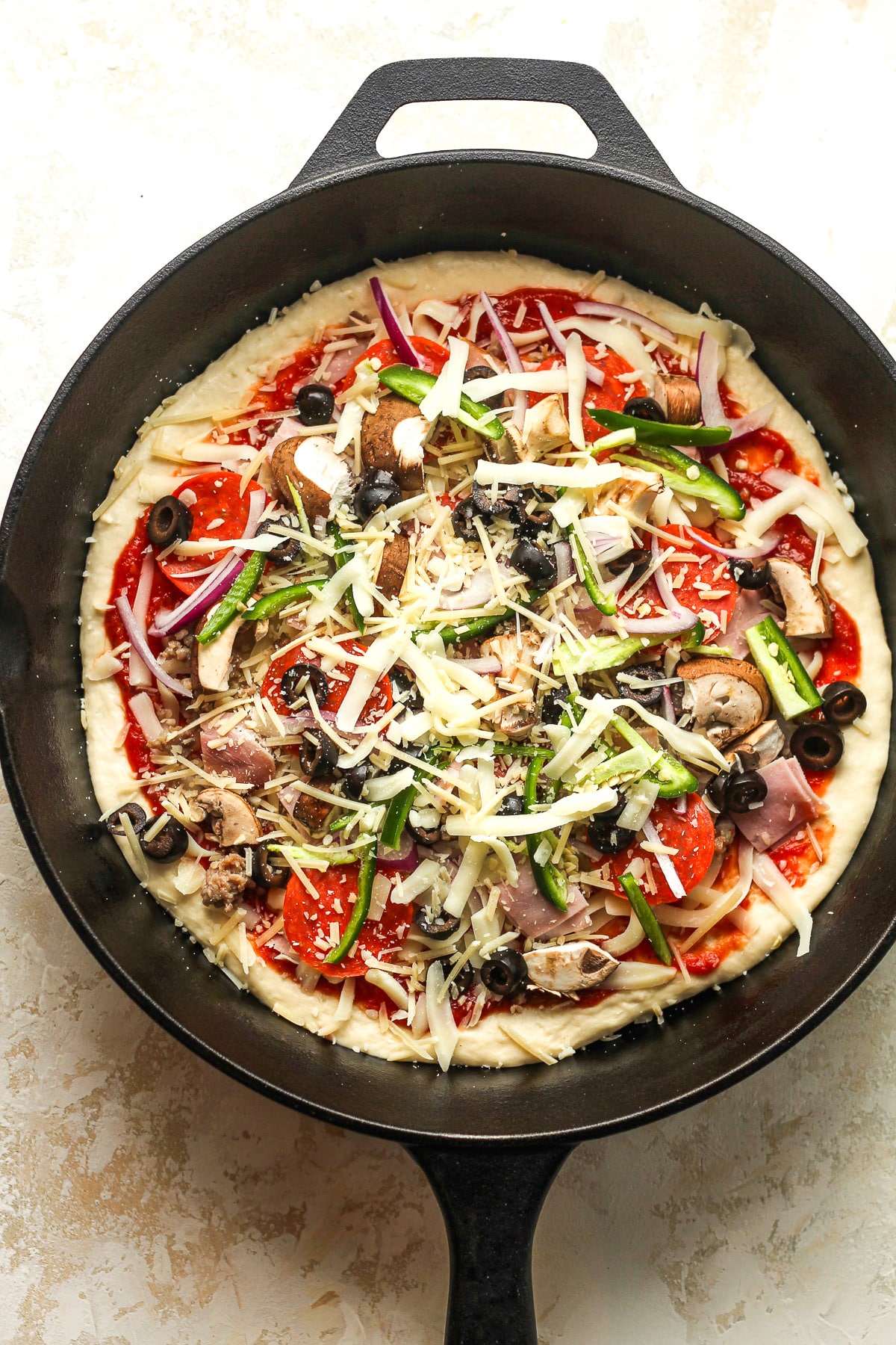 A skillet with the unbaked pizza.