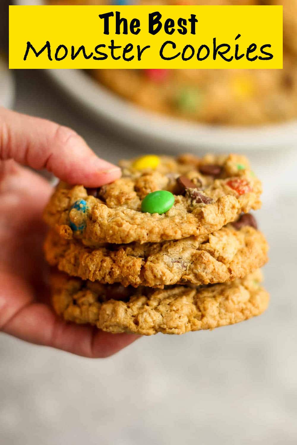 A hand holding a stack of the best monster cookies.