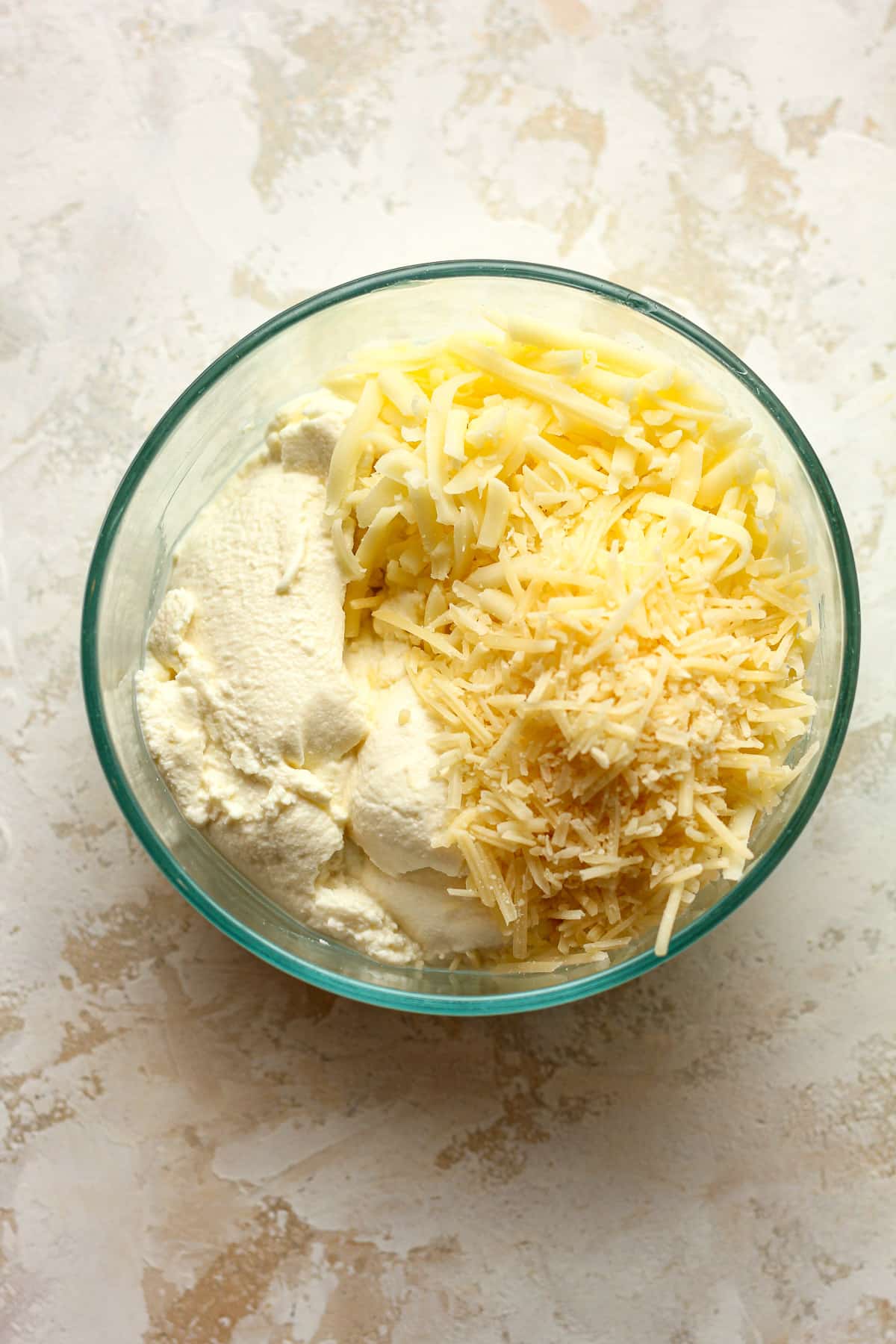 A bowl of the three cheeses - ricotta, mozzarella, and parmesan.