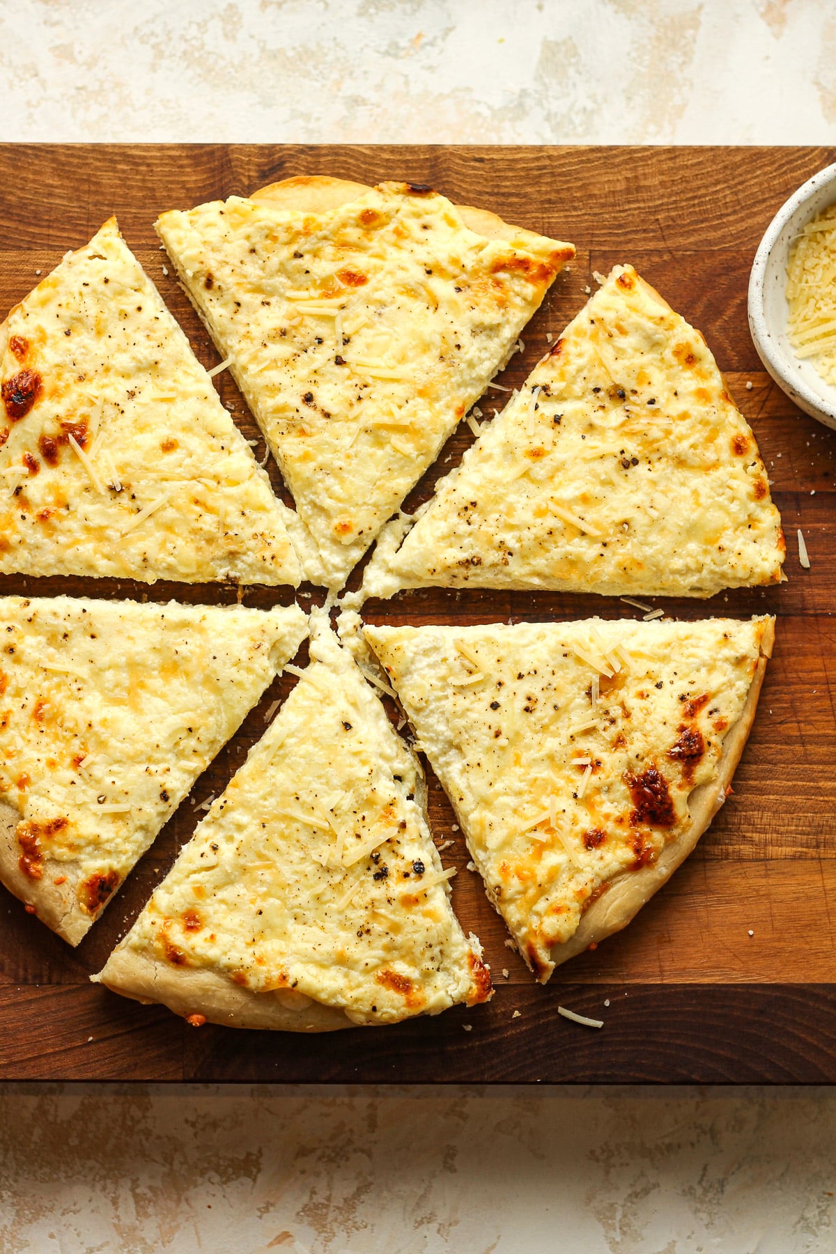 Overhead view of a cheese pizza sliced into six triangular slices.