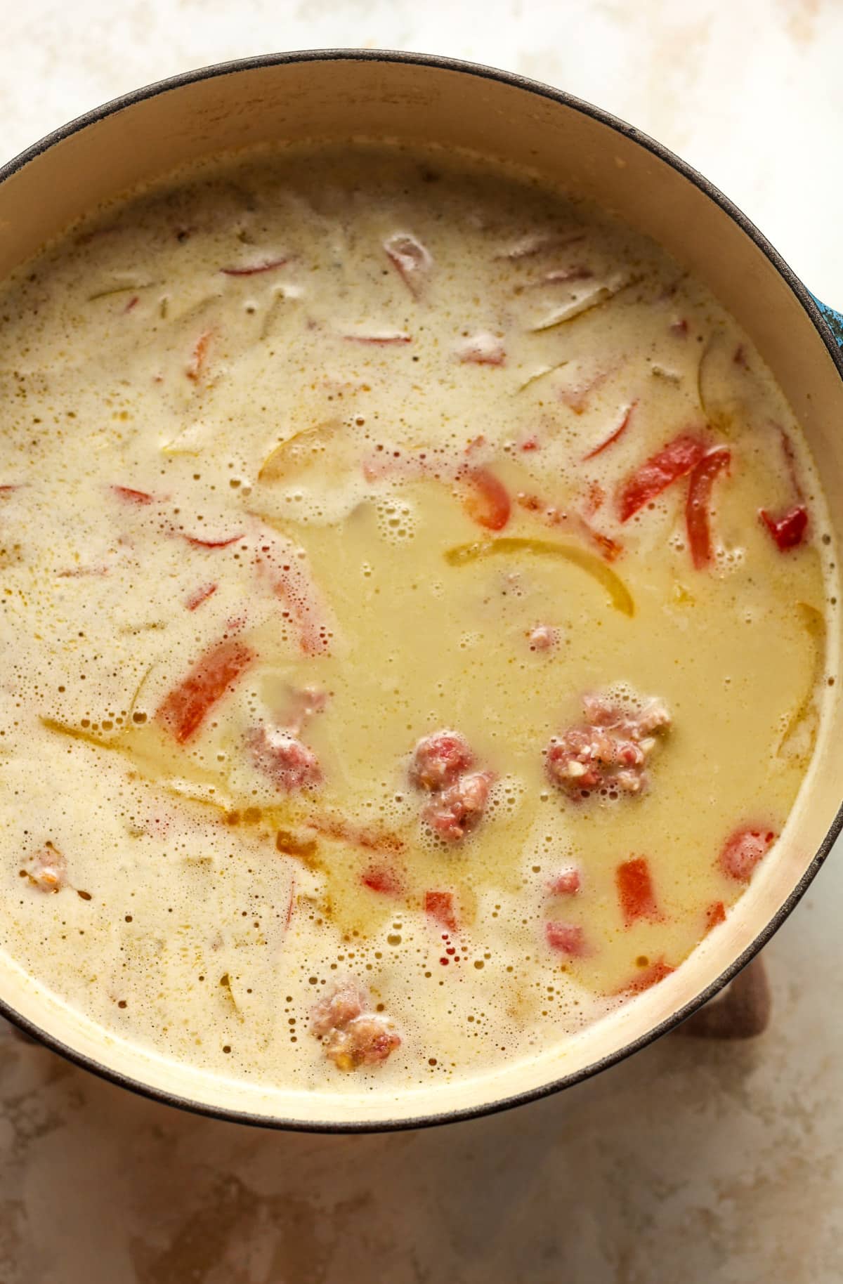 A pot of the broth mixture and the raw meatballs added in.