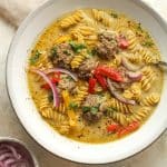 A bowl of Thai meatball soup with a spoon.