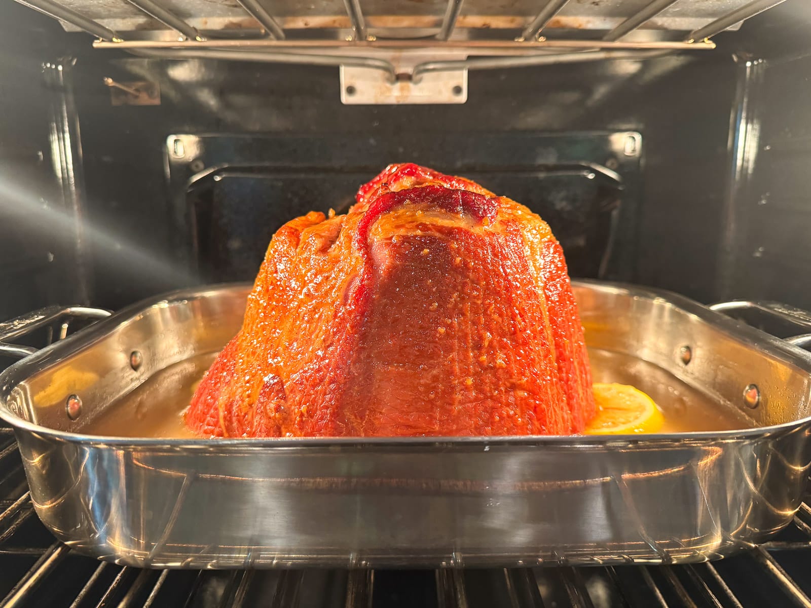 A bone in ham baking in the oven.