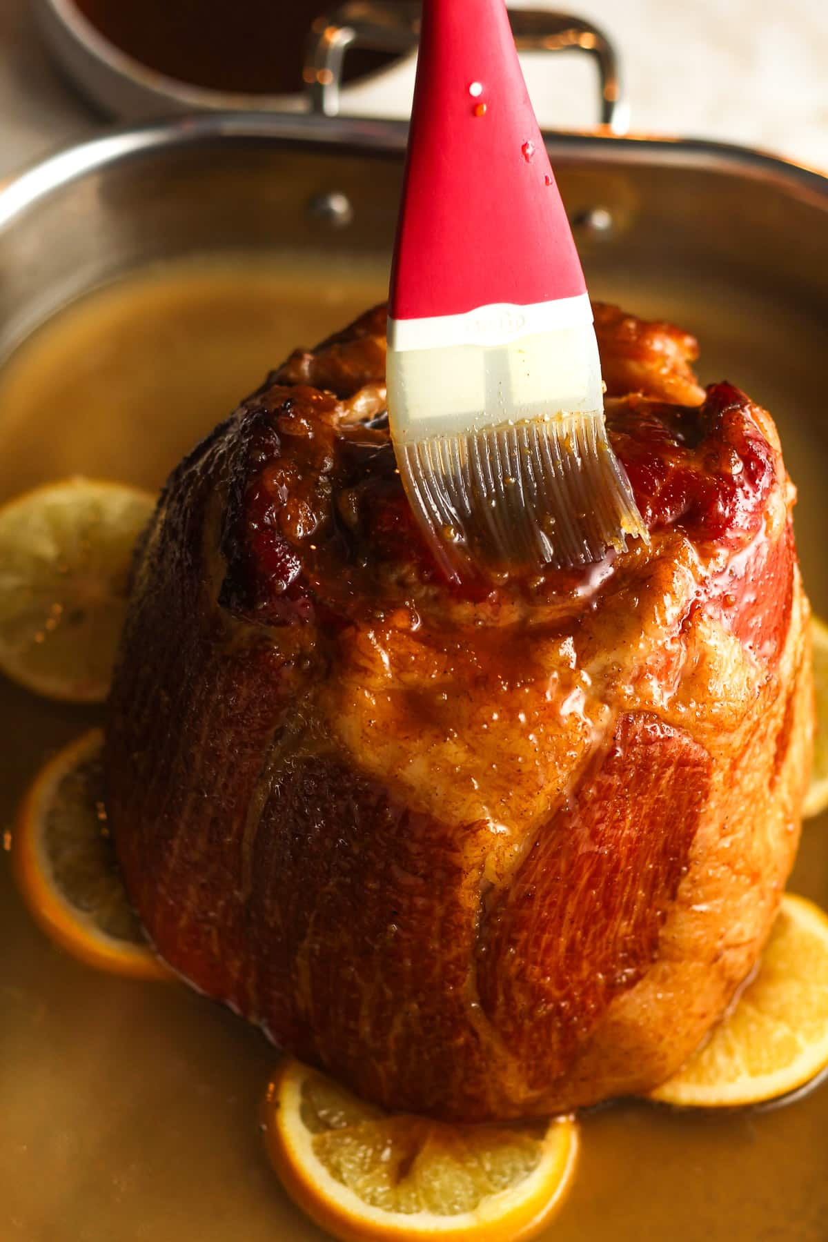 A brush adding maple glaze to the outside of the ham.