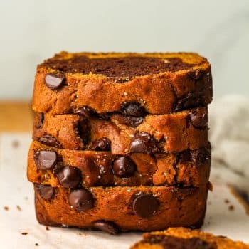 A stack of four slices of chocolate pumpkin bread.