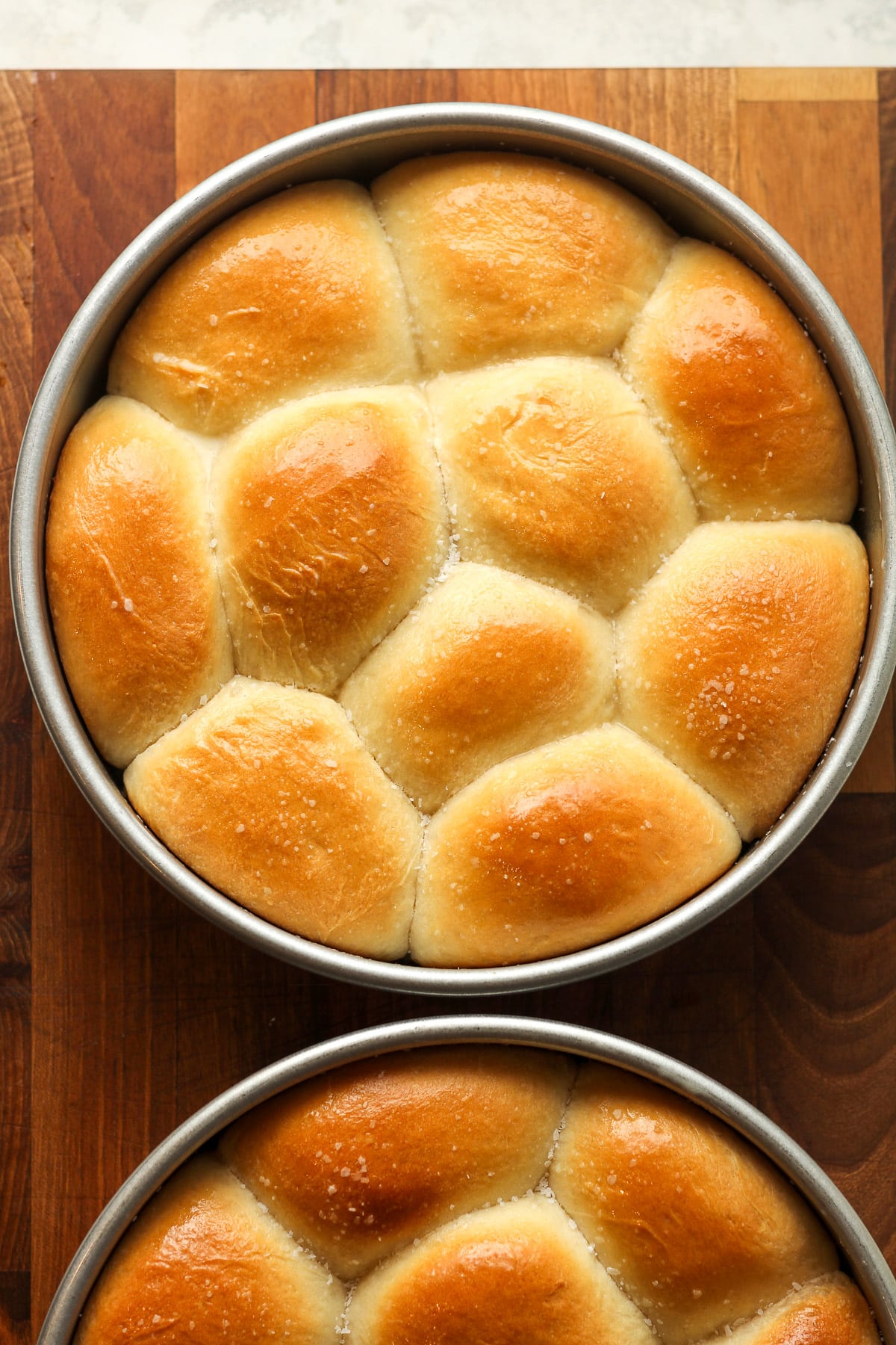 Two pans of baked dinner rolls.