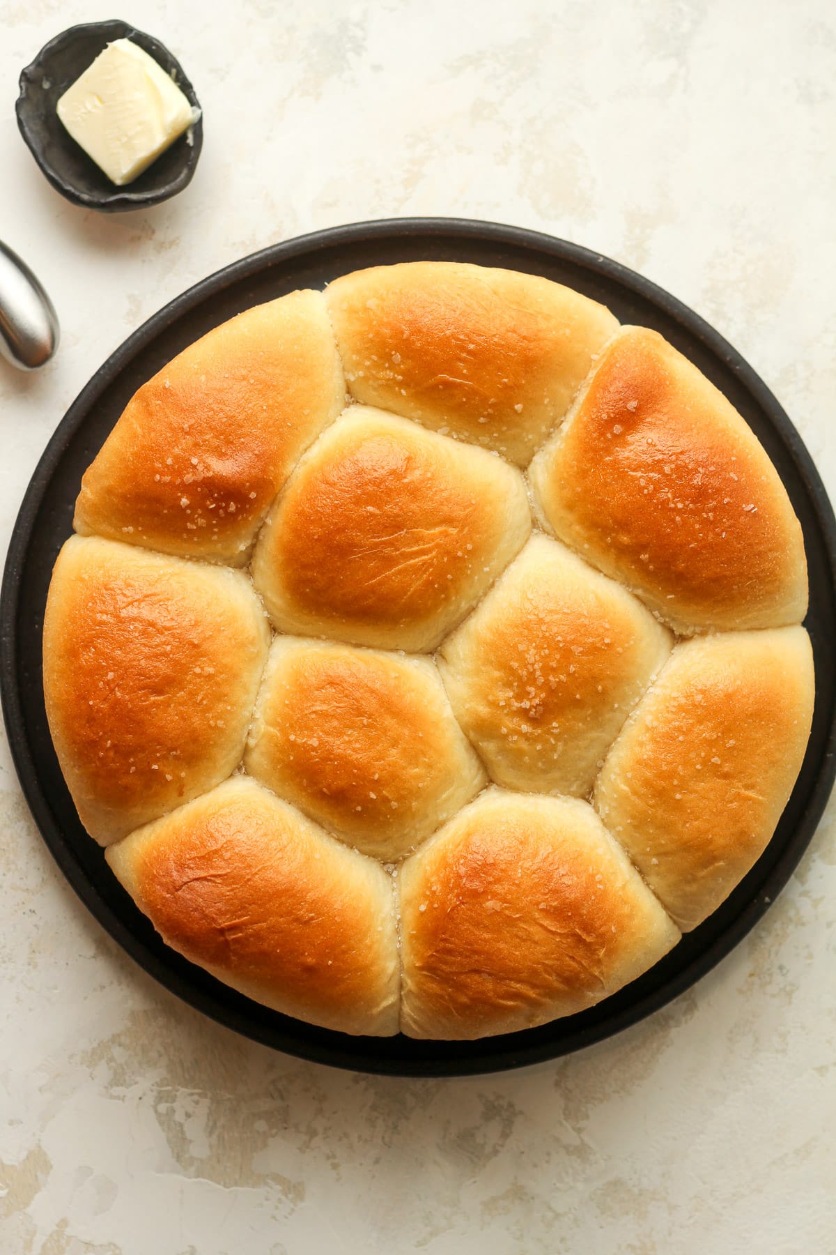 Overhead view of a plate with a round of dinner rolls.