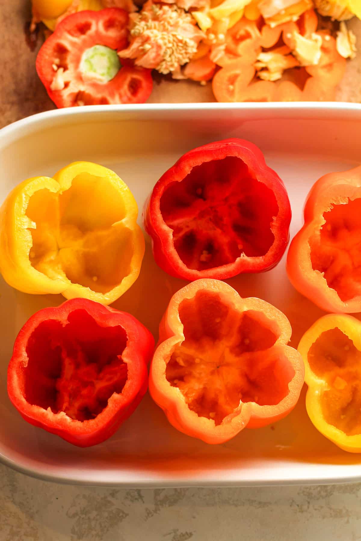 Overhead view of six raw bell peppers after removing the tops.