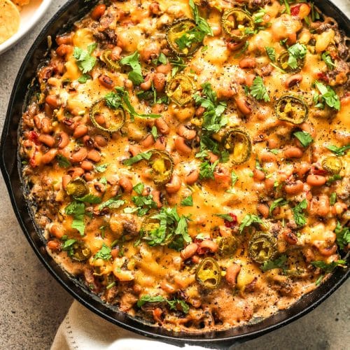 A cast iron skillet with black eyed pea dip.