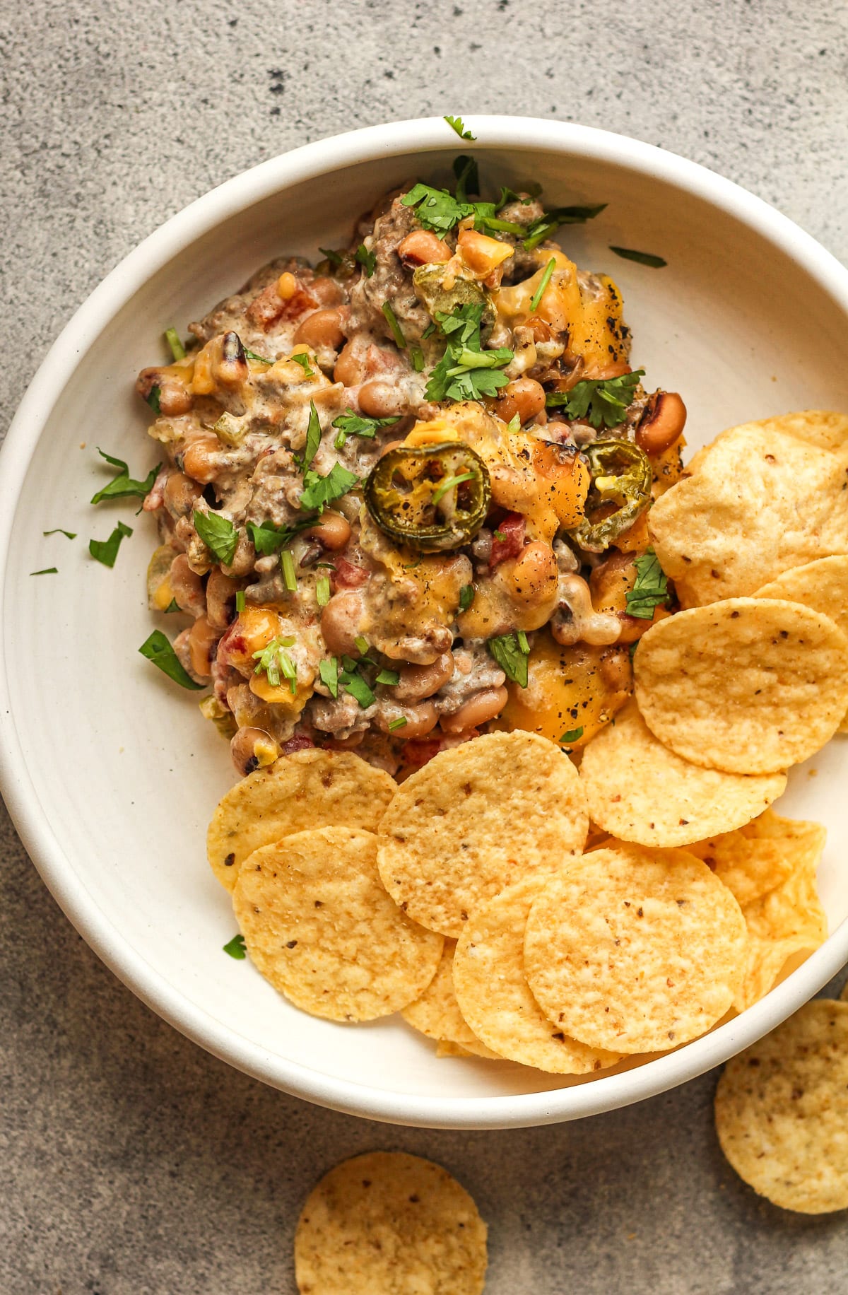 A bowl of the hot black eyed pea dip with chips.