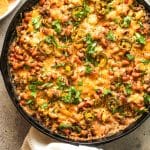 A skillet of hot black eyed pea dip with cheese on top.