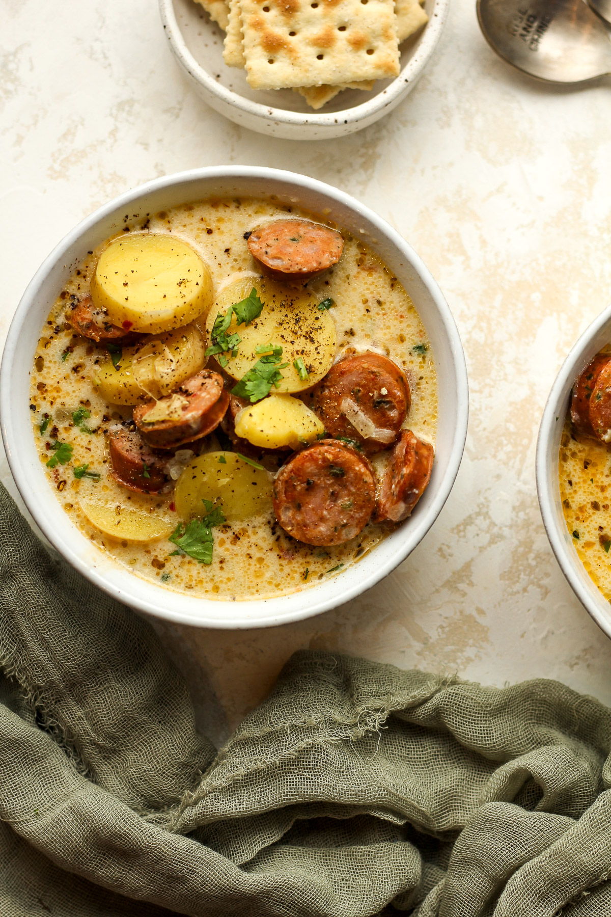 A bowl of kielbasa potato soup with cilantro on top.