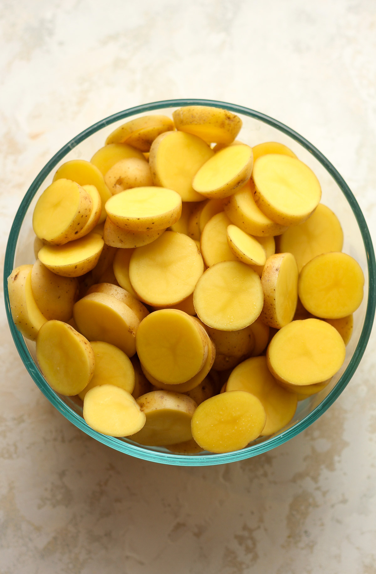 A bowl of sliced yellow potatoes.