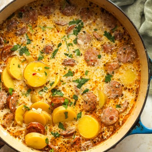 A large pot of kielbasa potato soup with a green napkin.