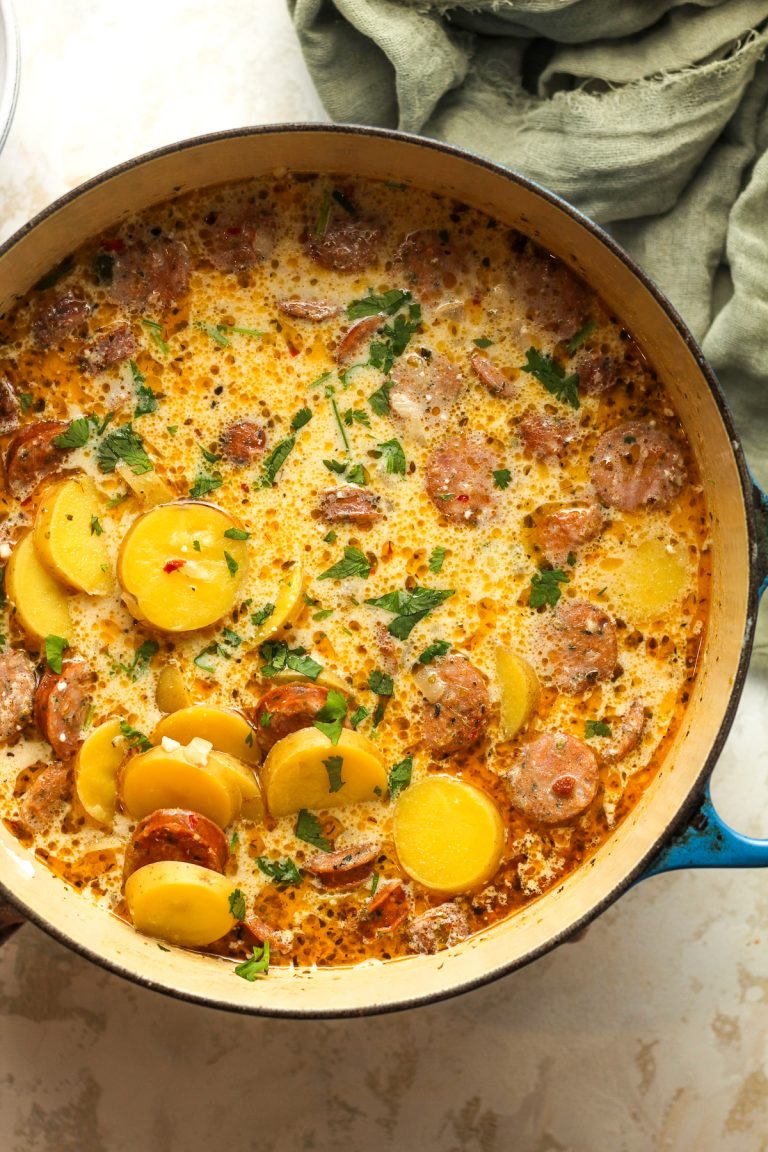 A large pot of kielbasa potato soup with a green napkin.