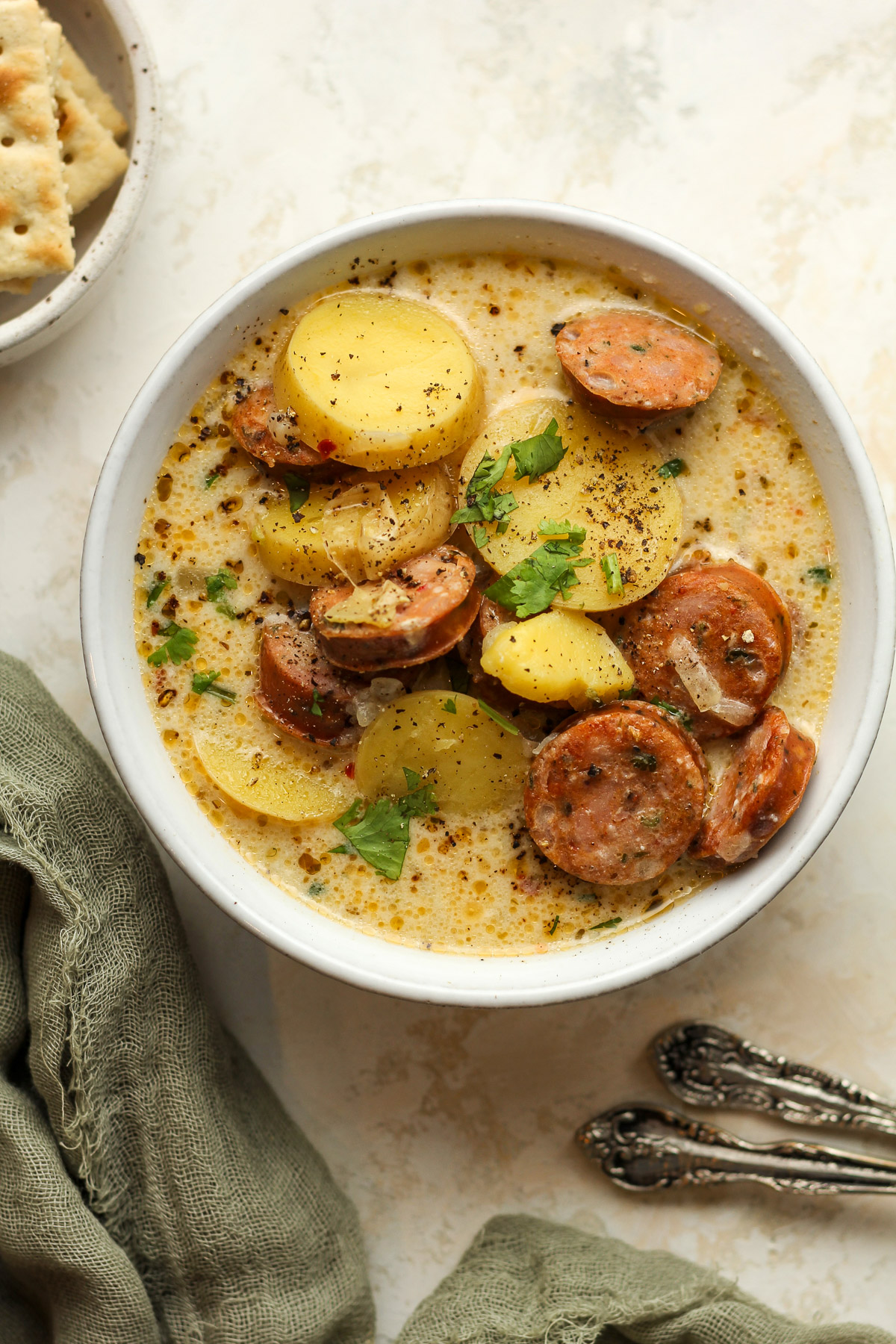 A bowl of potato sausage soup in a creamy broth.