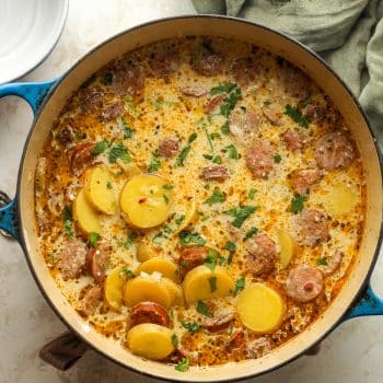 A large pot of kielbasa potato soup with a creamy broth.