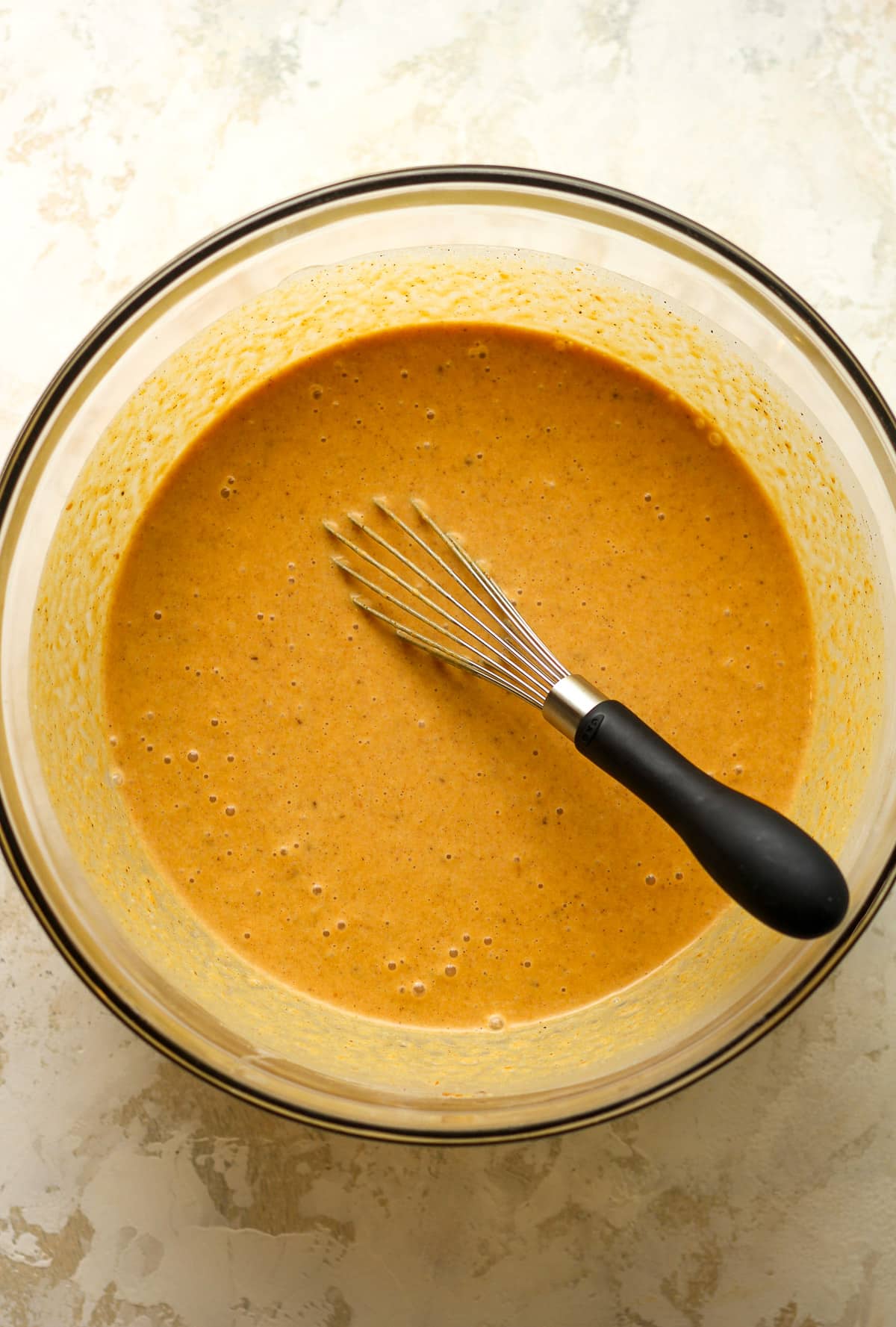 A bowl of the pumpkin mixture with a whisk.