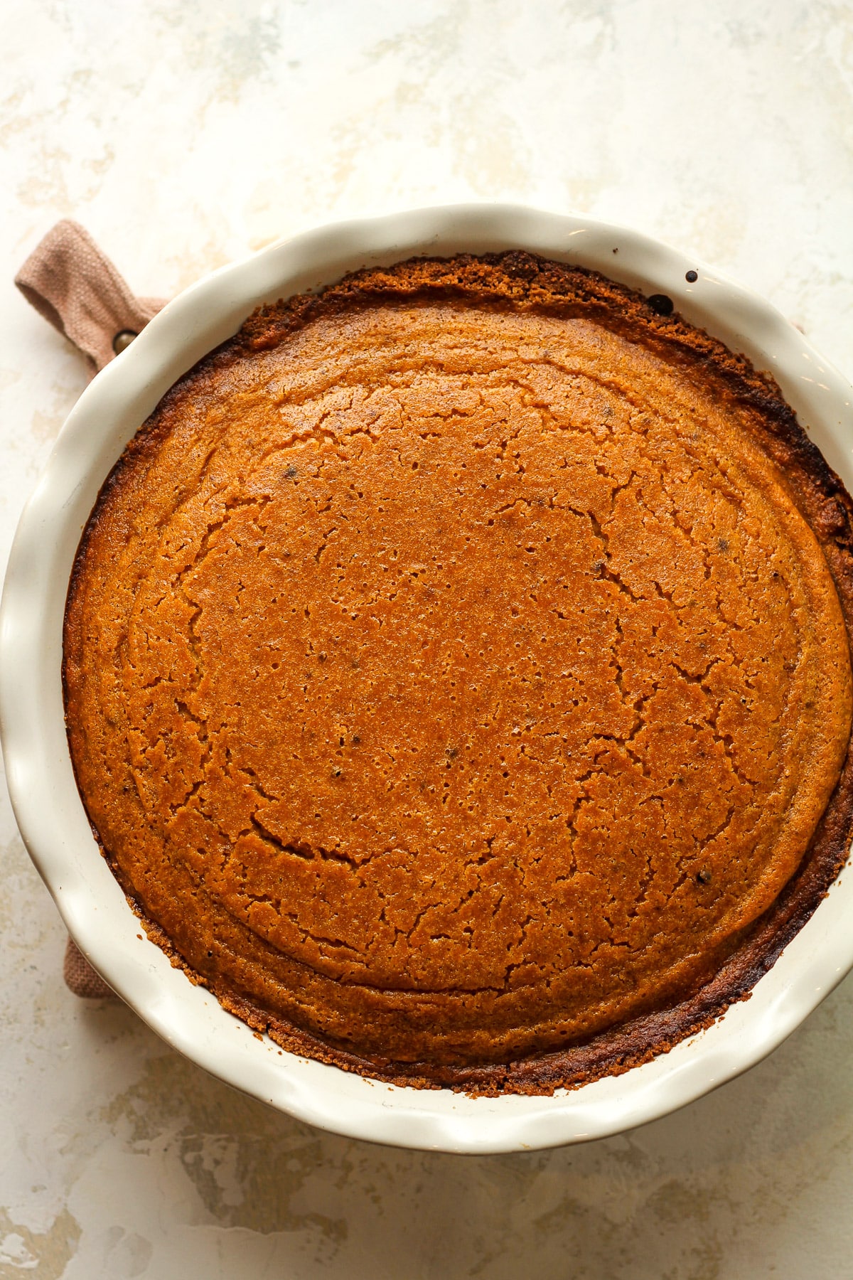 Overhead view of a 9-inch just baked pumpkin pie in a graham cracker crust.