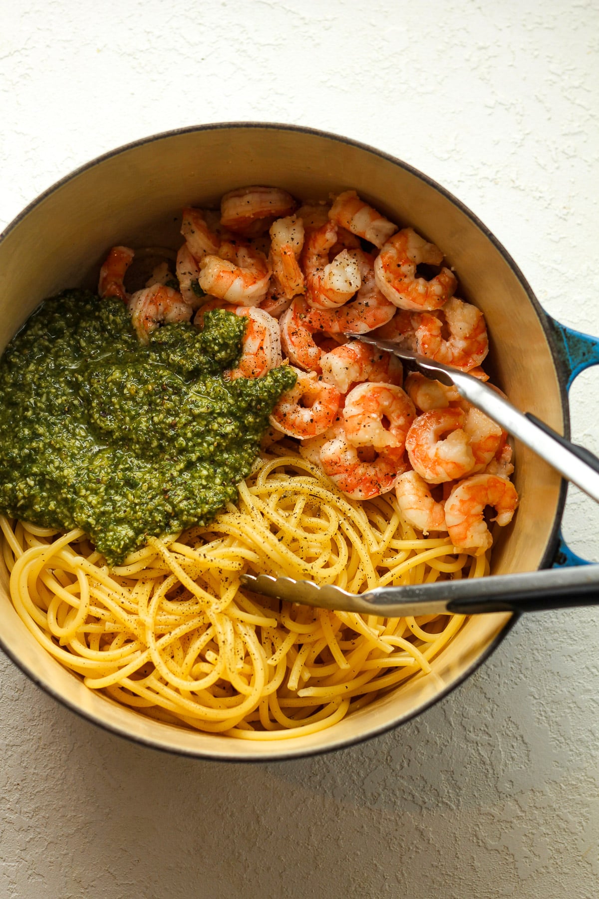 A pot of the pasta, shrimp, and pesto sauce before mixing together.