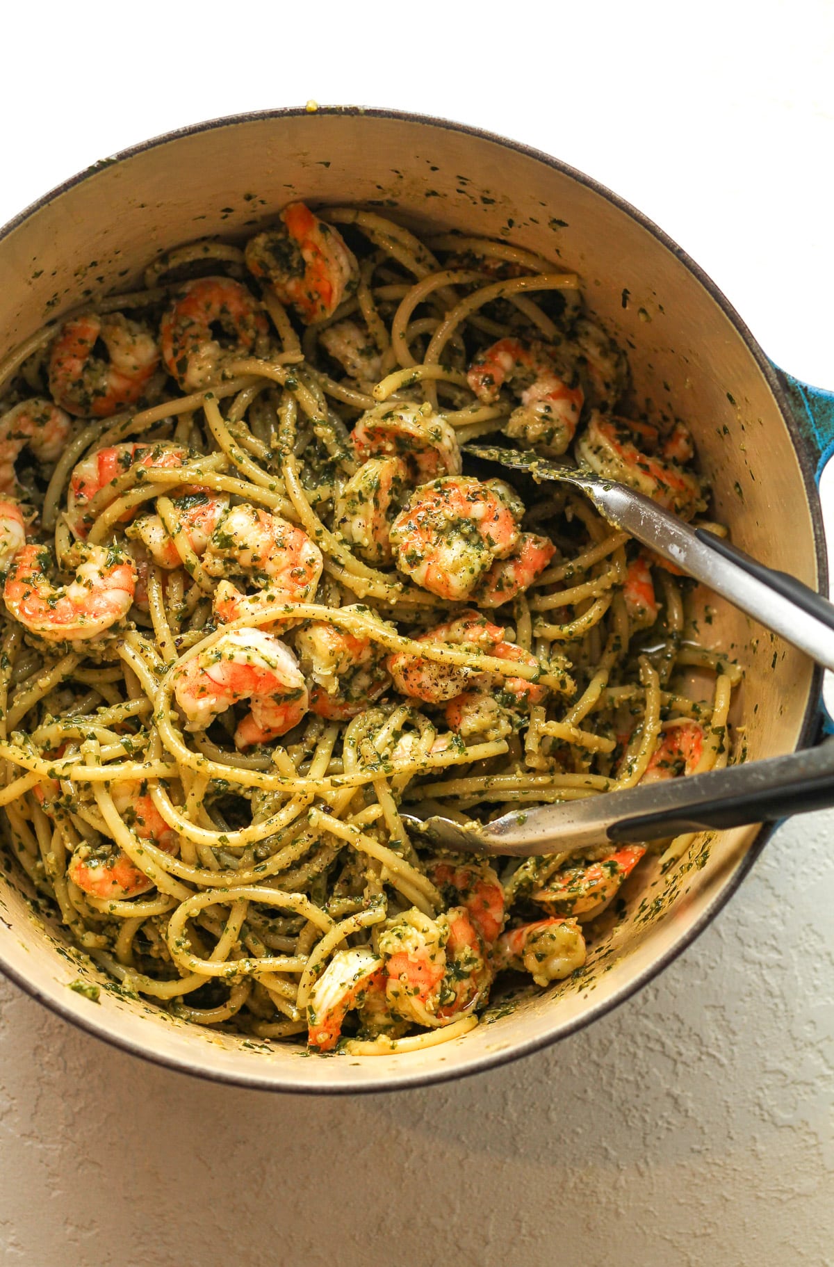 A Dutch oven with the combined shrimp pesto pasta.