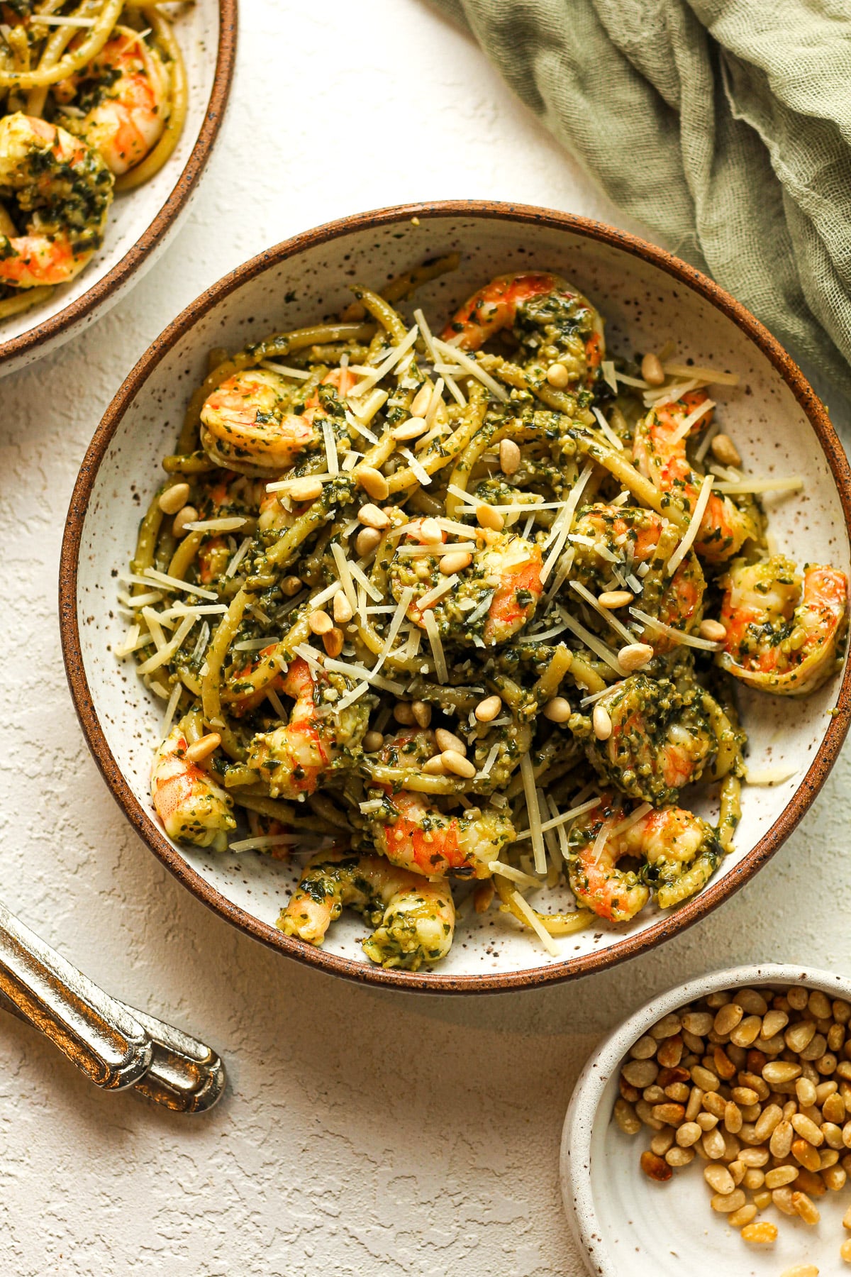 Two bowls of pesto pasta with shrimp.