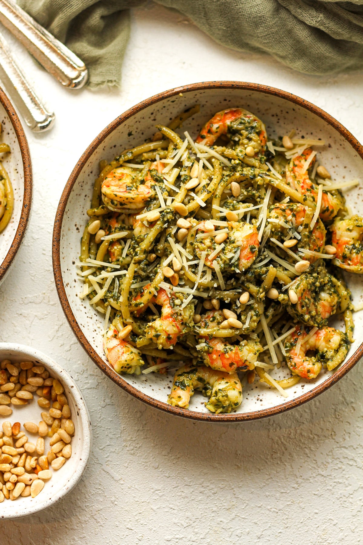 A bowl of the shrimp pasta with pesto, topped with pine nuts.