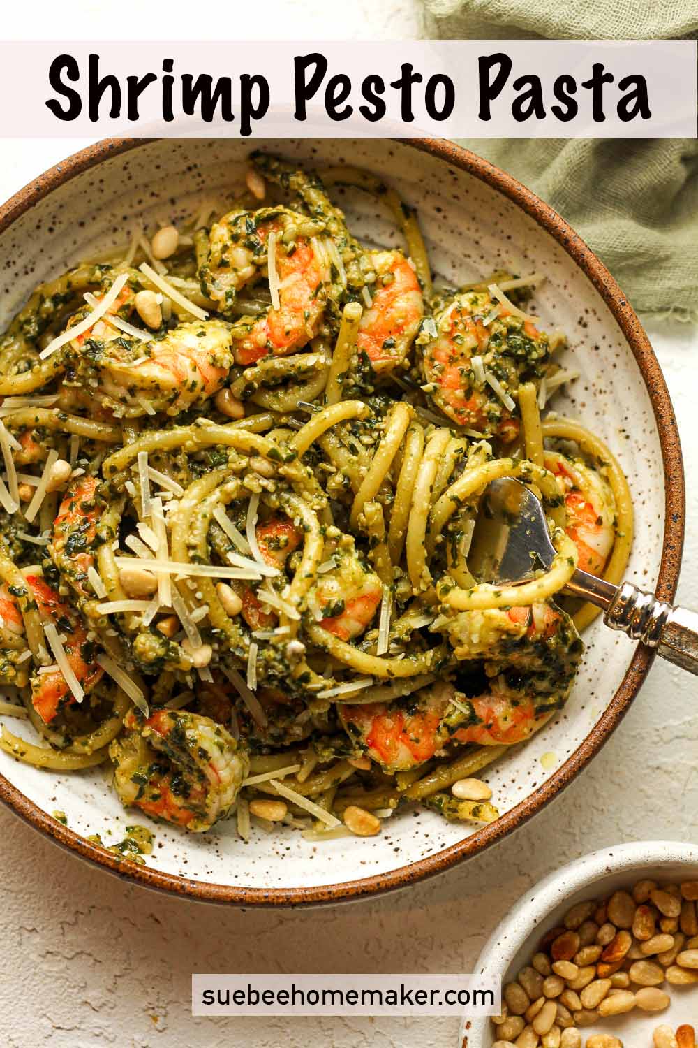 A bowl of shrimp pesto pasta with a fork.