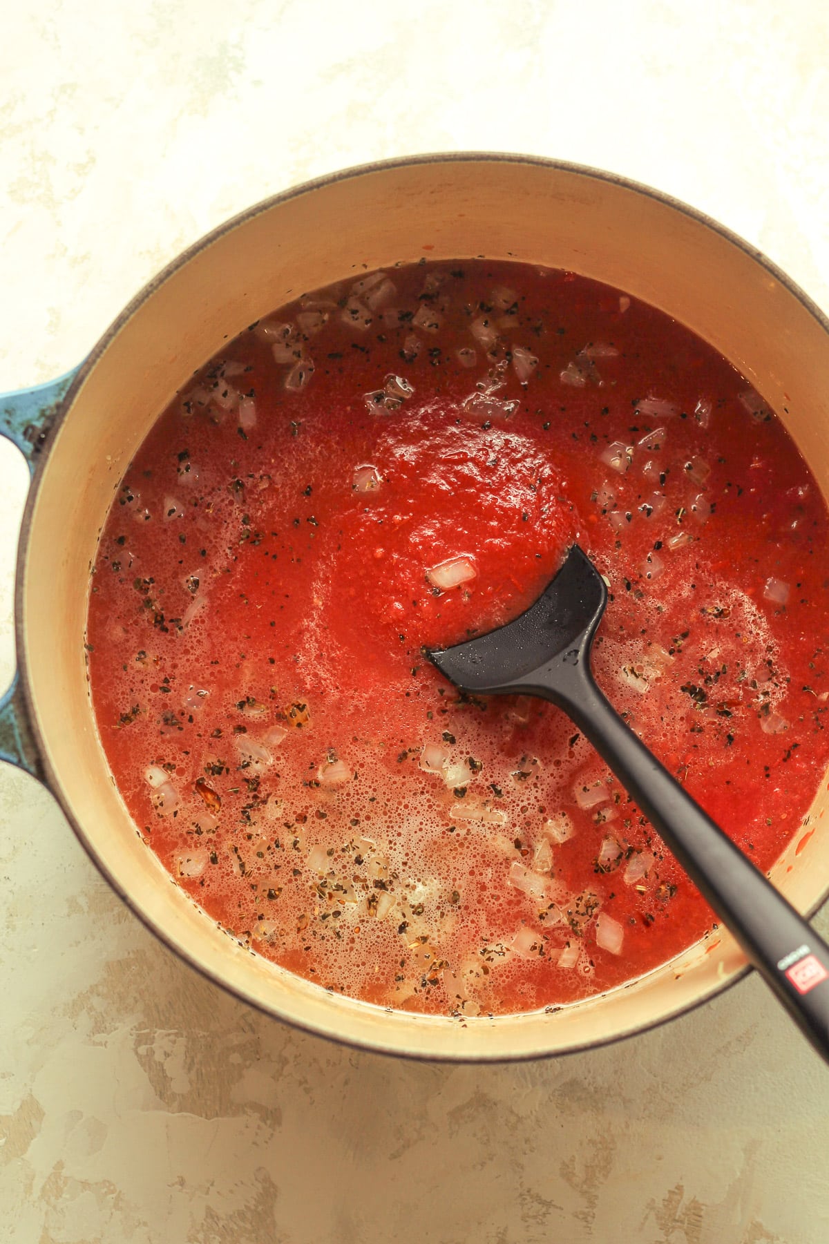 A pot of the soup after adding in tomatoes.