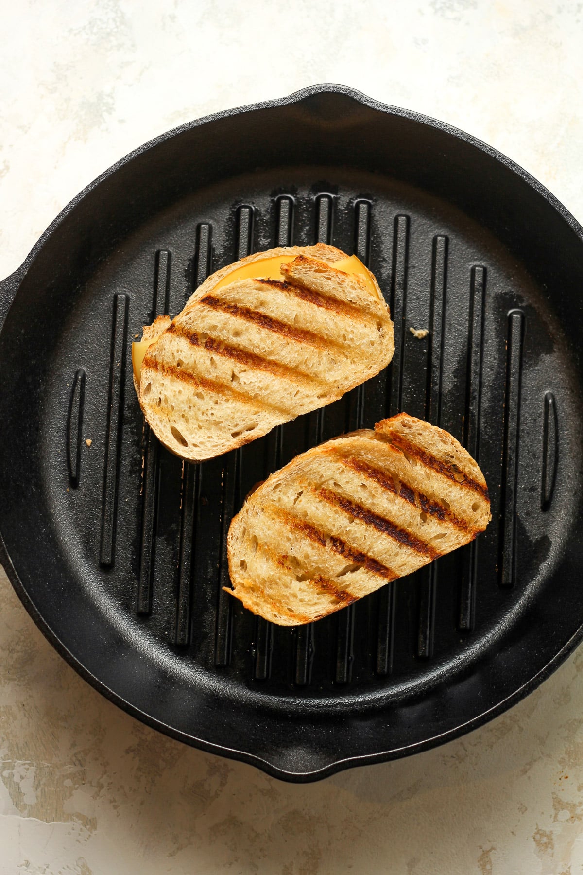 A skillet of two grilled cheese sandwiches.