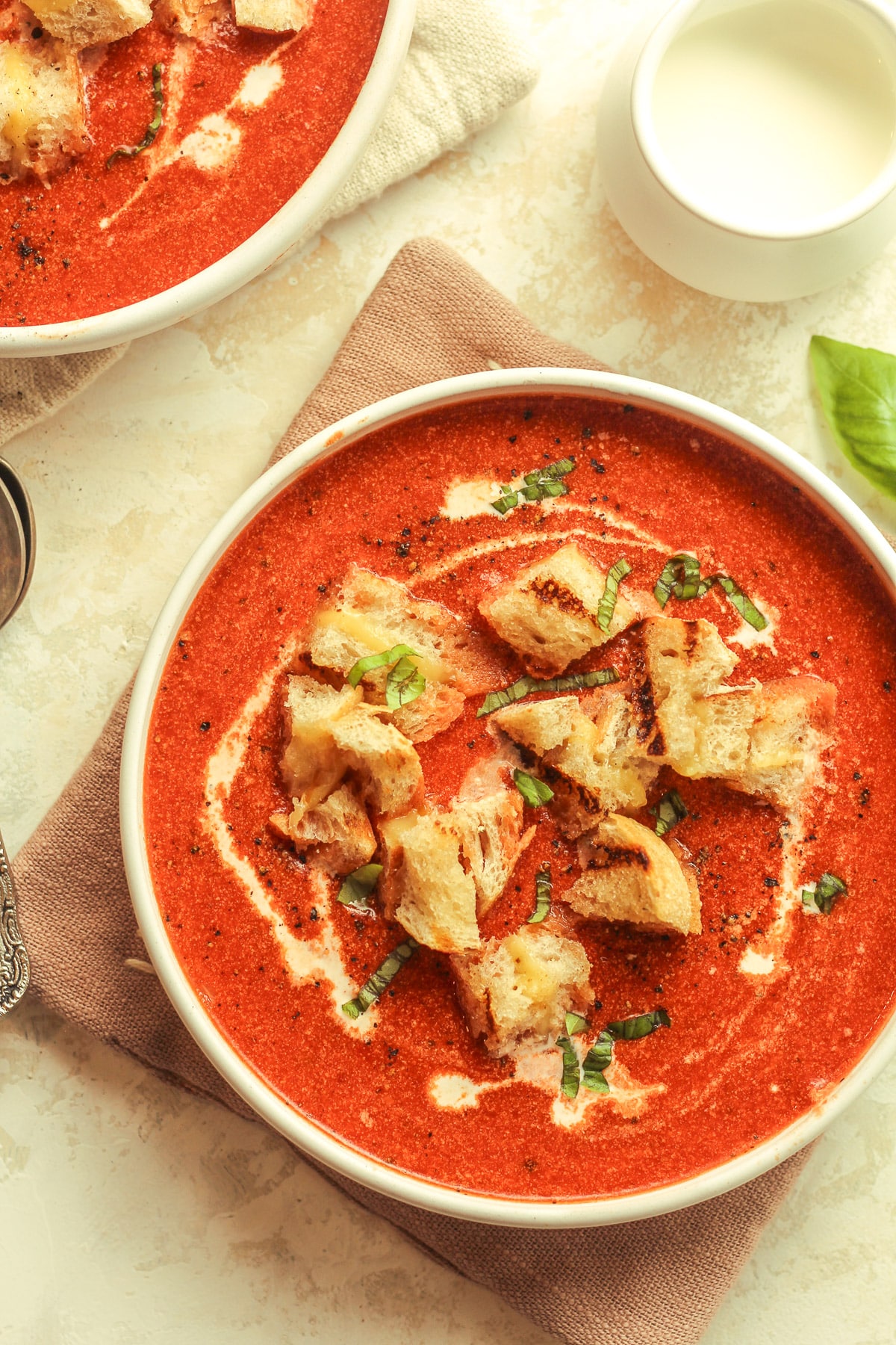 Two bowls of soup with grilled cheese croutons.