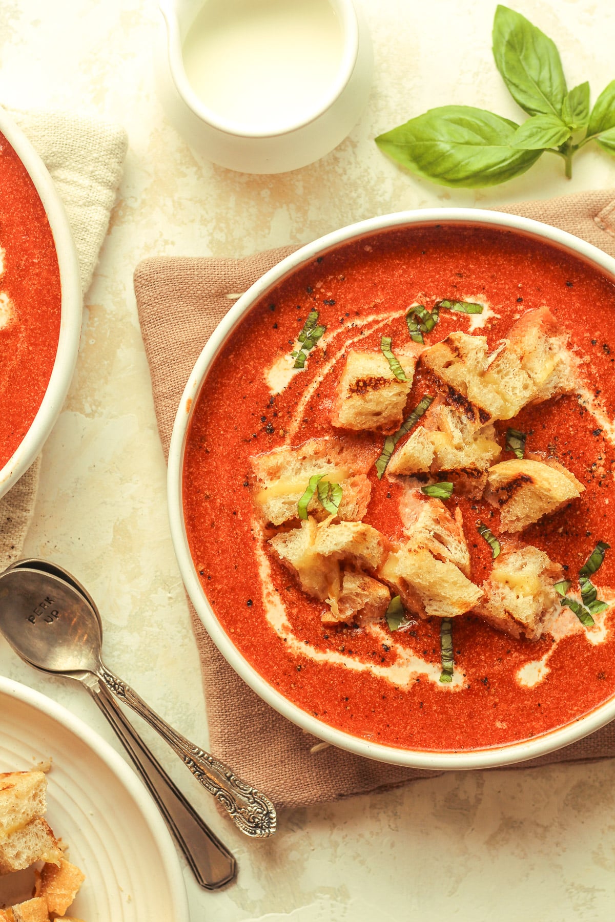 Two bowls of creamy tomato soup.