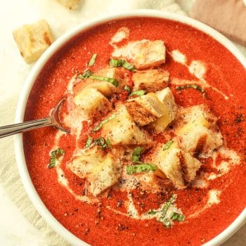 Closeup on a bowl of tomato soup and grilled cheese croutons