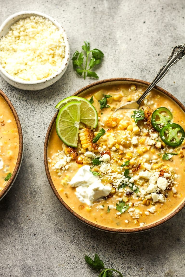 Two bowls of Mexican Street Corn chowder with lime slices.