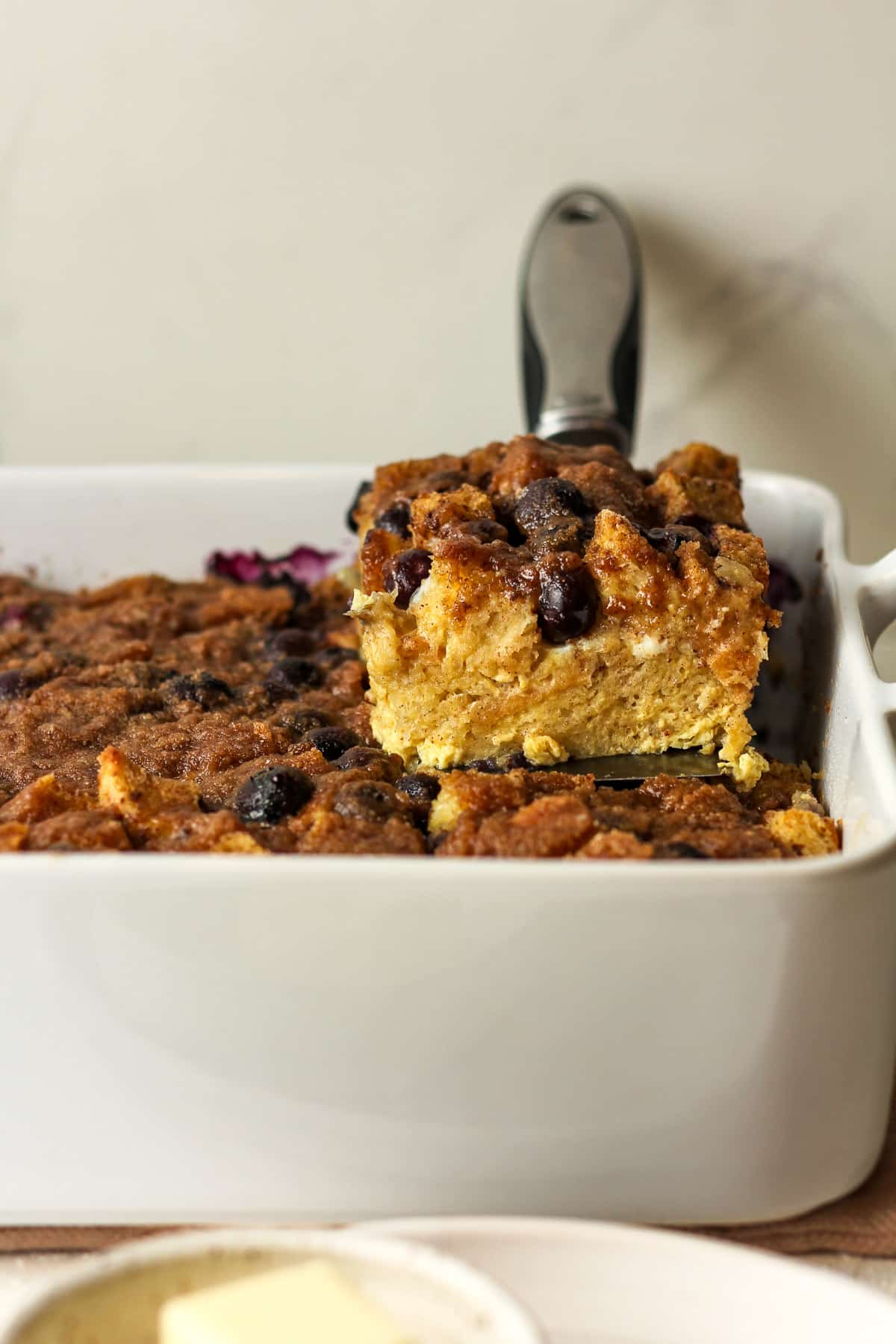 Side view of a casserole with a piece of French toast casserole sitting on top.